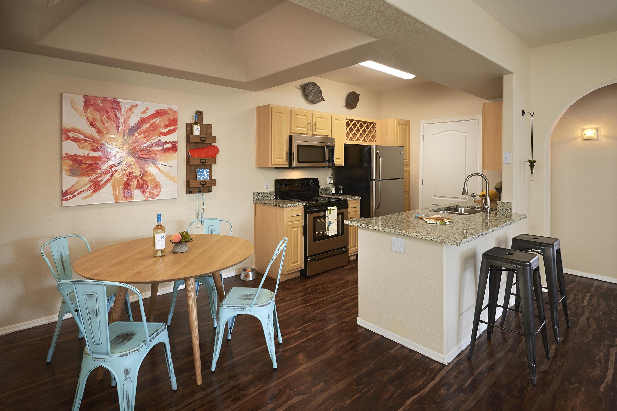 Modern kitchen featuring light wooden cabinetry, stainless steel appliances, and a granite countertop.