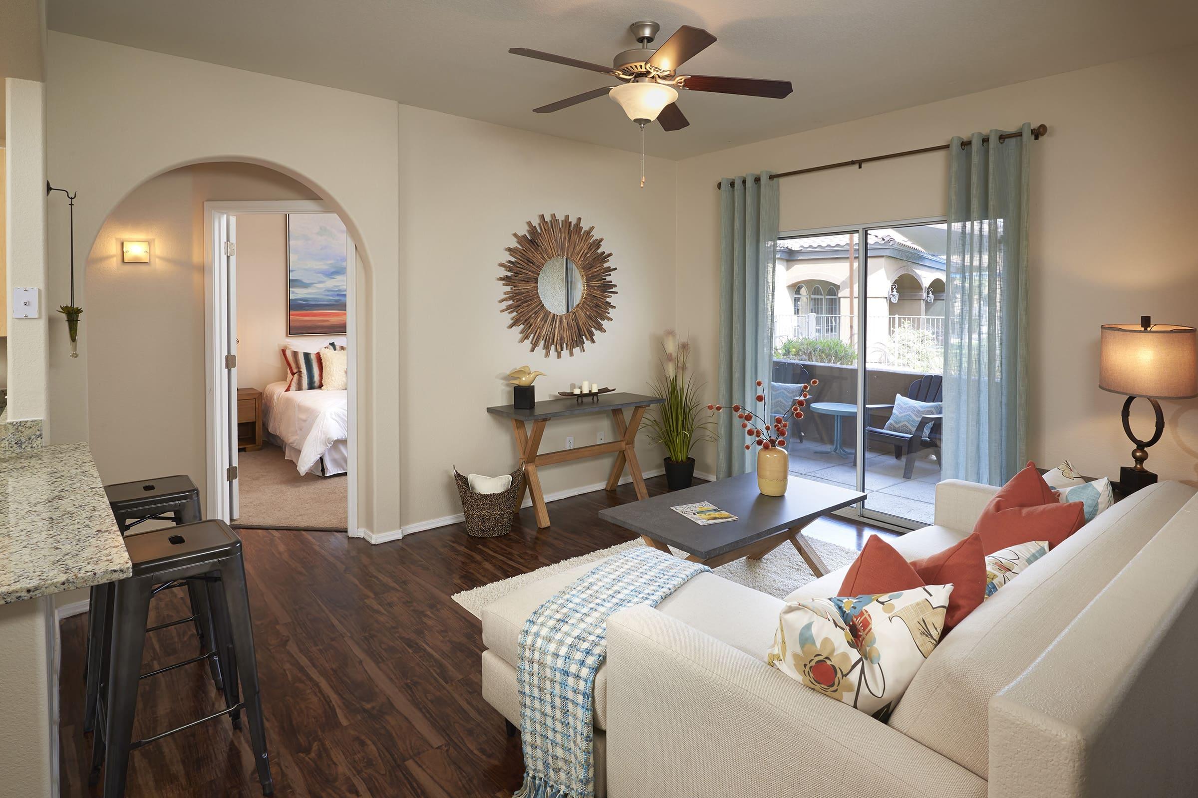 A cozy living room featuring a light-colored sofa with decorative pillows, a coffee table, and a patterned throw.