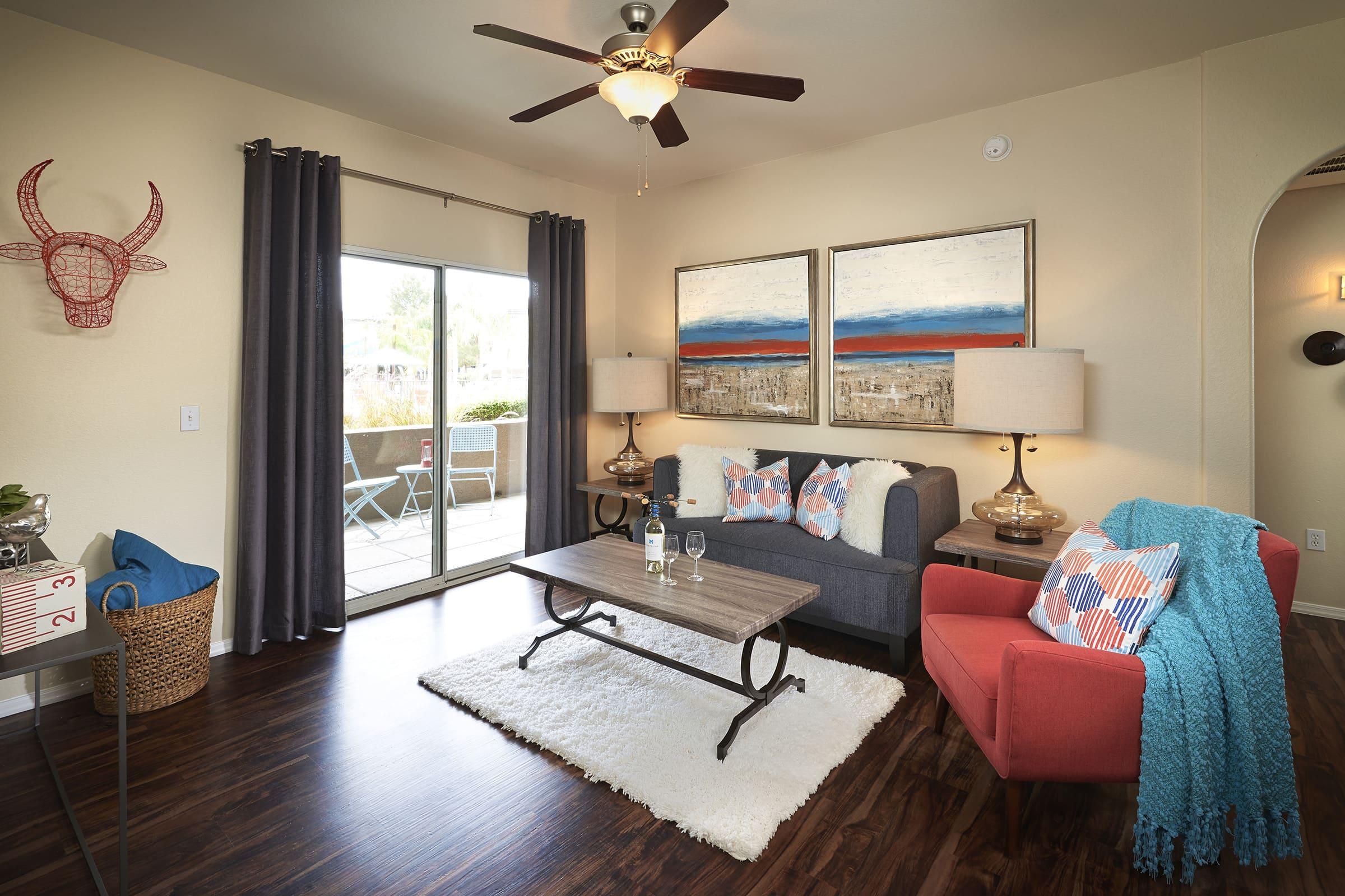 A cozy living room featuring a gray sofa and a red armchair, with a wooden coffee table in the center.