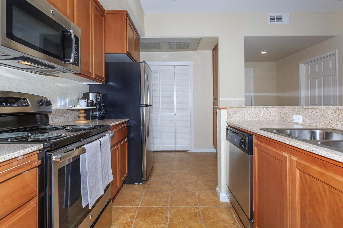 a large kitchen with stainless steel appliances and wooden cabinets