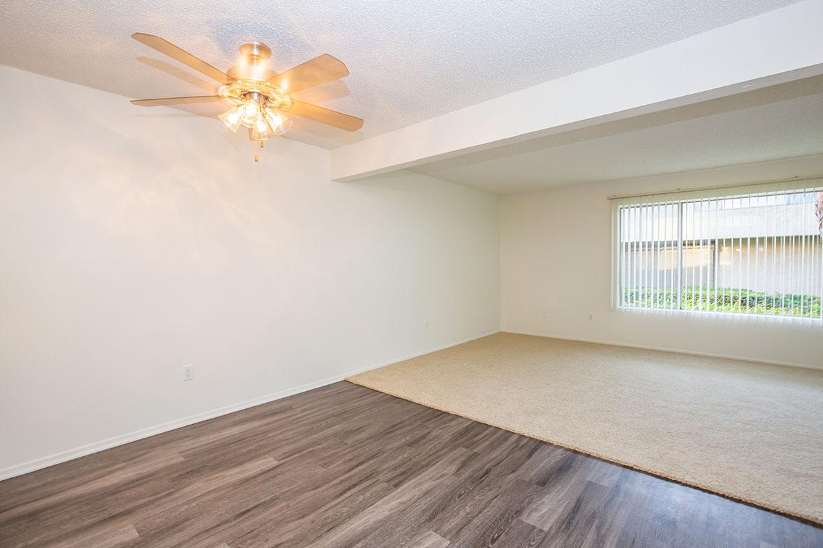 Dining room with wooden floors and carpeted living room