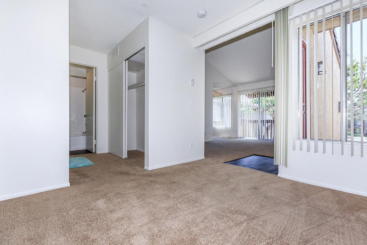 Bedroom with open bathroom and closet doors