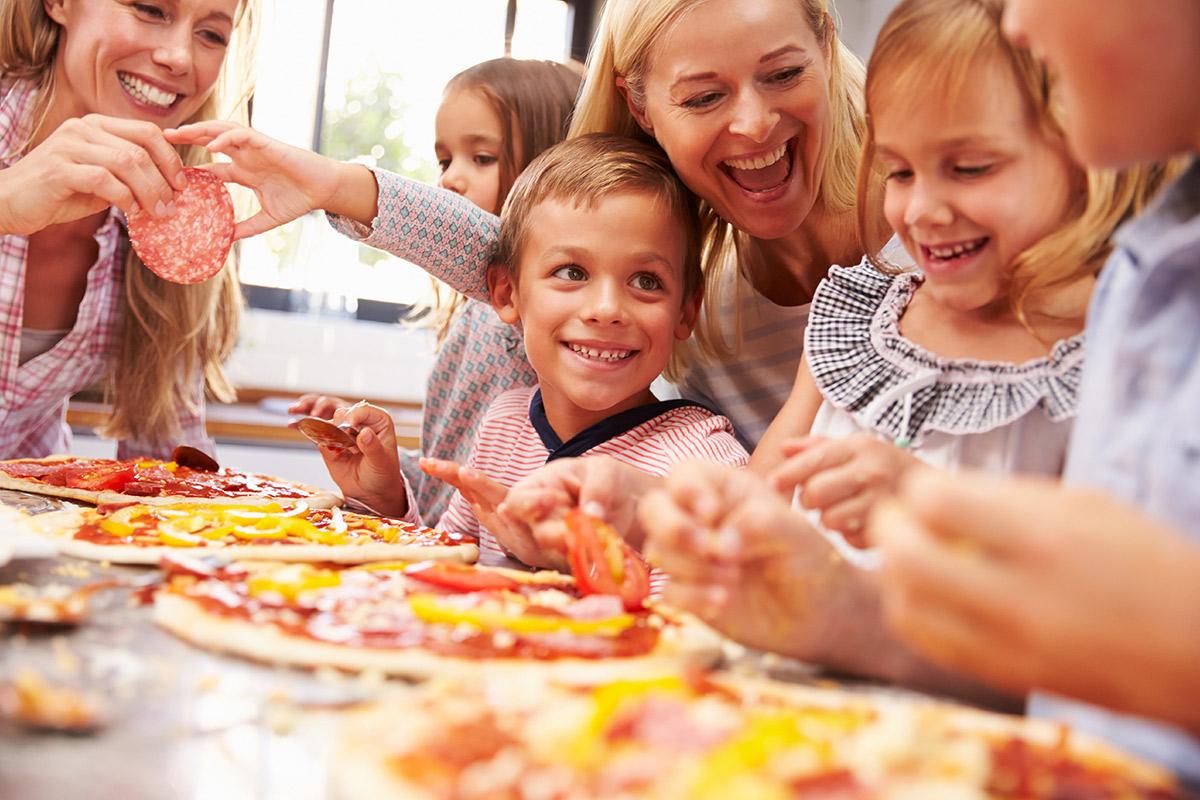 a group of people sitting at a table eating pizza