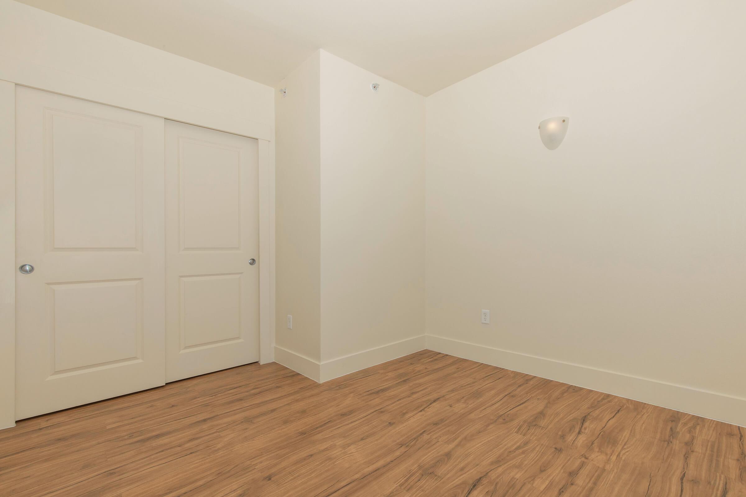 a bedroom with a wooden floor