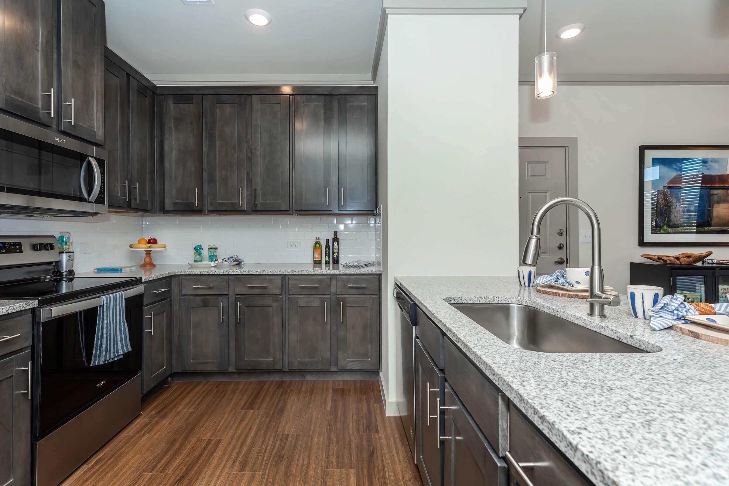 a modern kitchen with stainless steel appliances and wooden cabinets