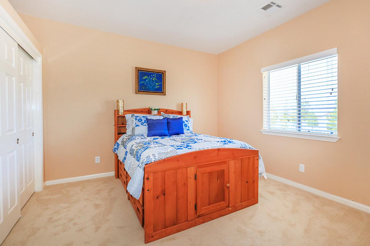 a bedroom with a bed and desk in a room