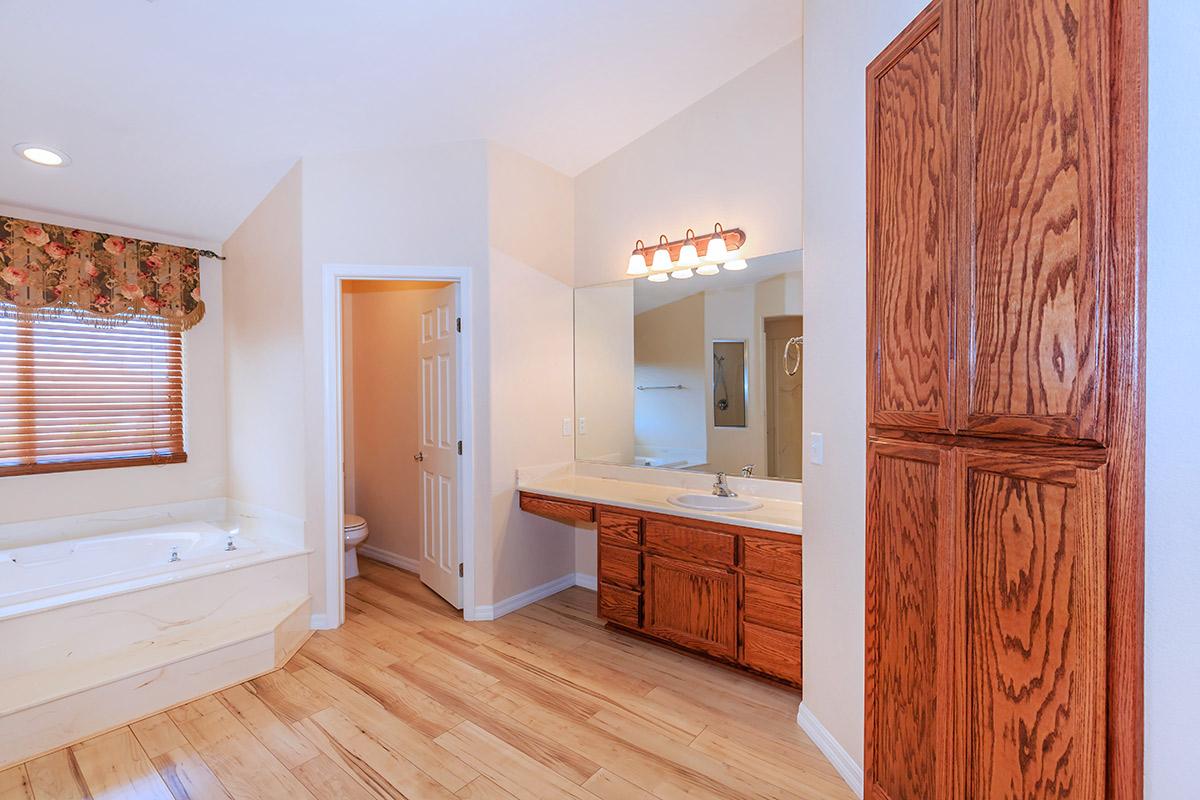 a kitchen with wooden cabinets and a wood floor