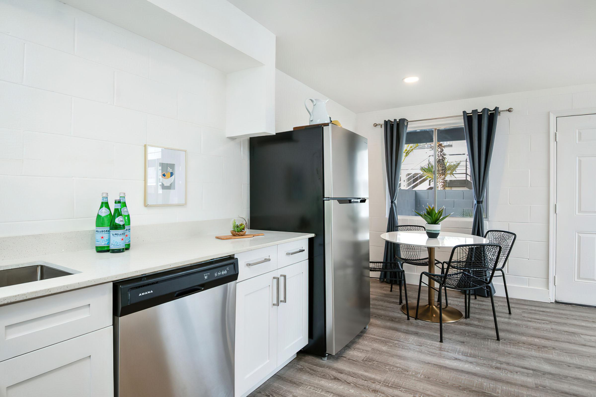 a kitchen with a refrigerator and table in a room