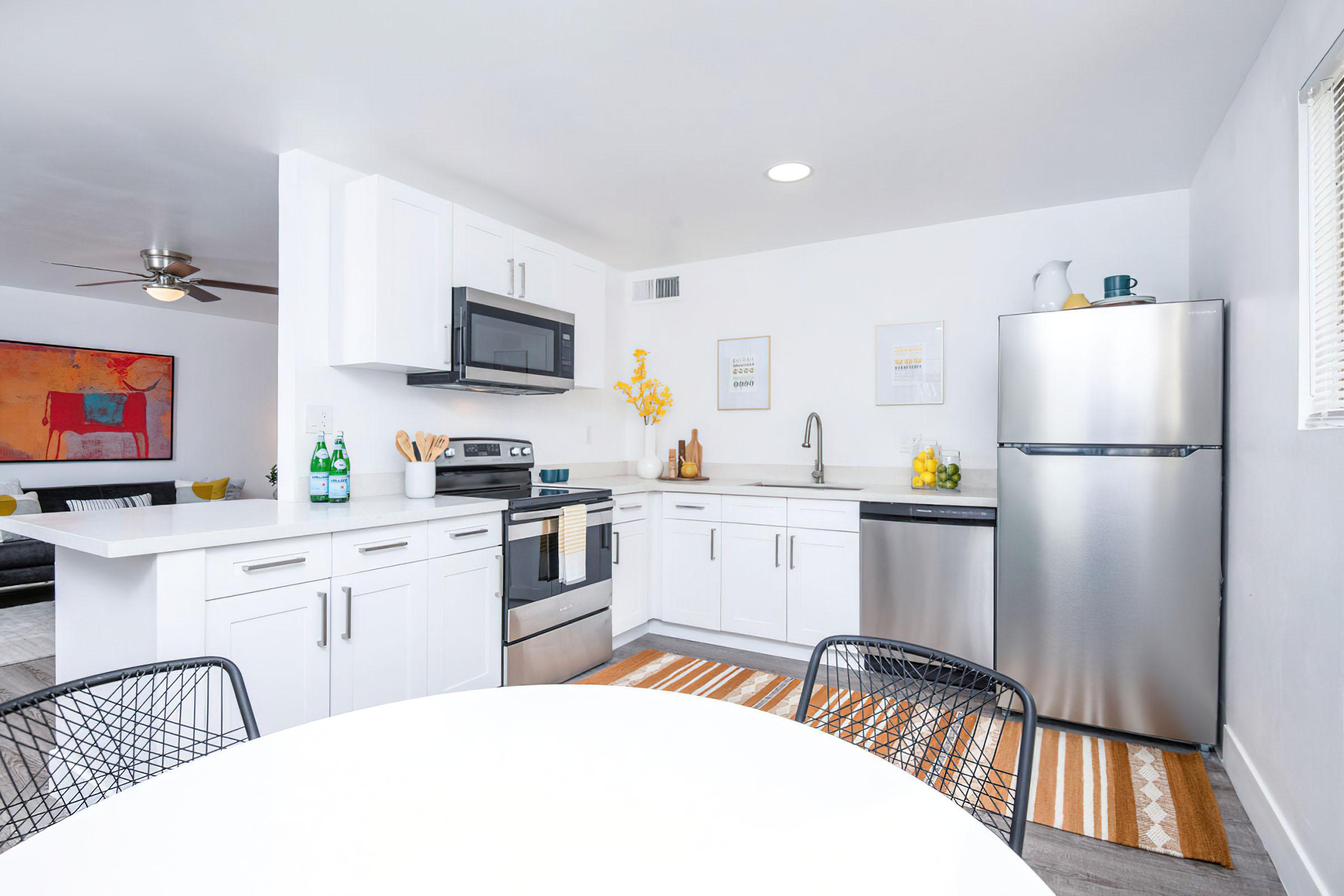 a kitchen with a refrigerator and table in a room