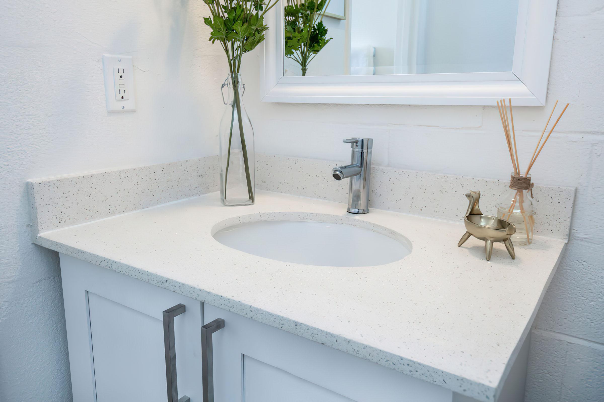 a sink sitting under a mirror next to a window