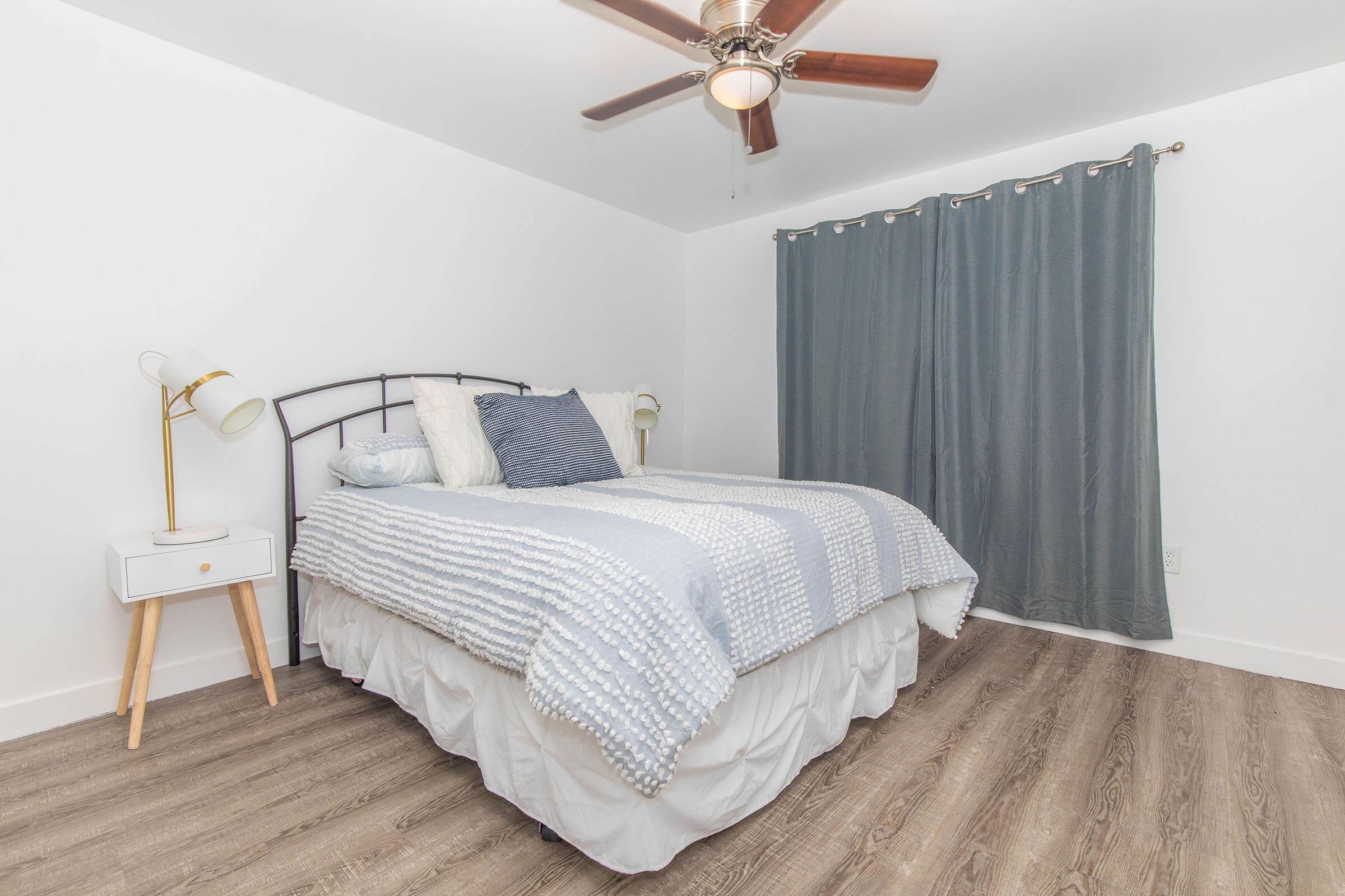 a bedroom with a bed and desk in a small room