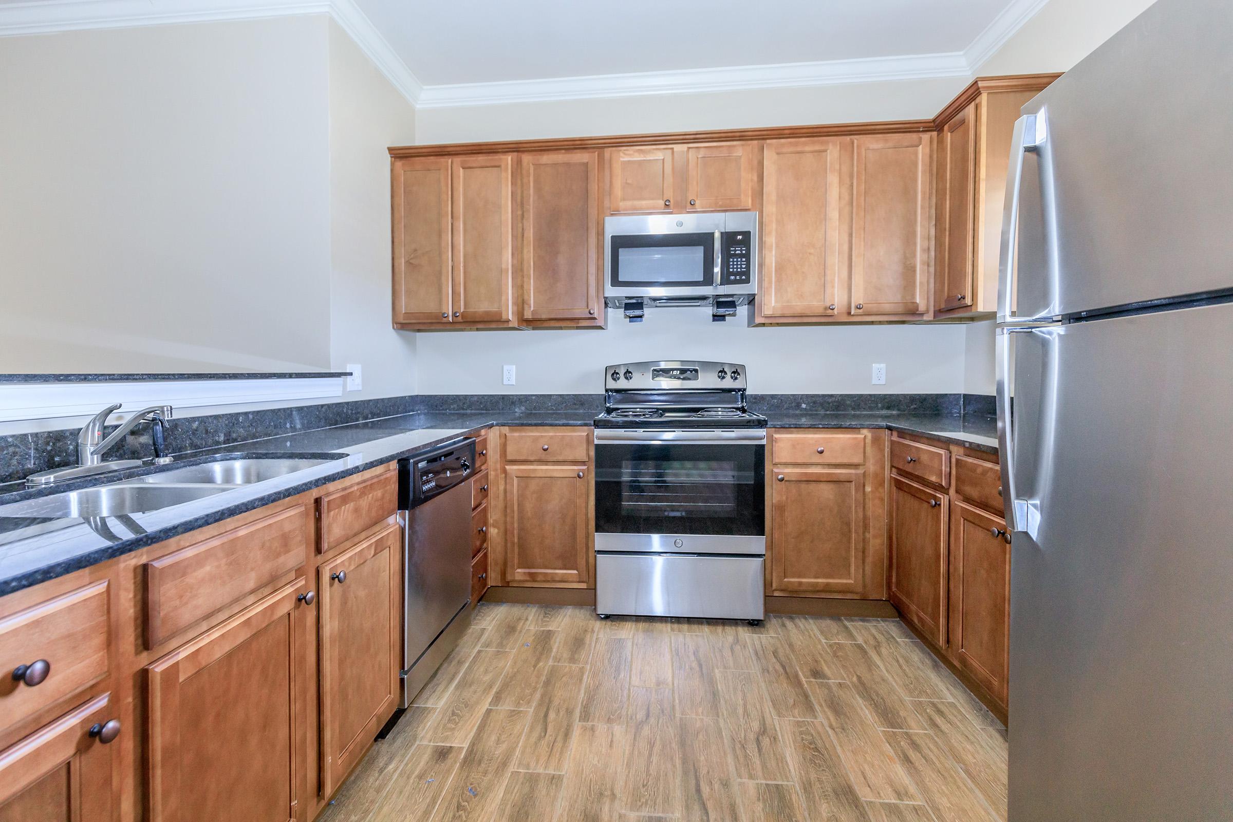 a large kitchen with stainless steel appliances and wooden cabinets