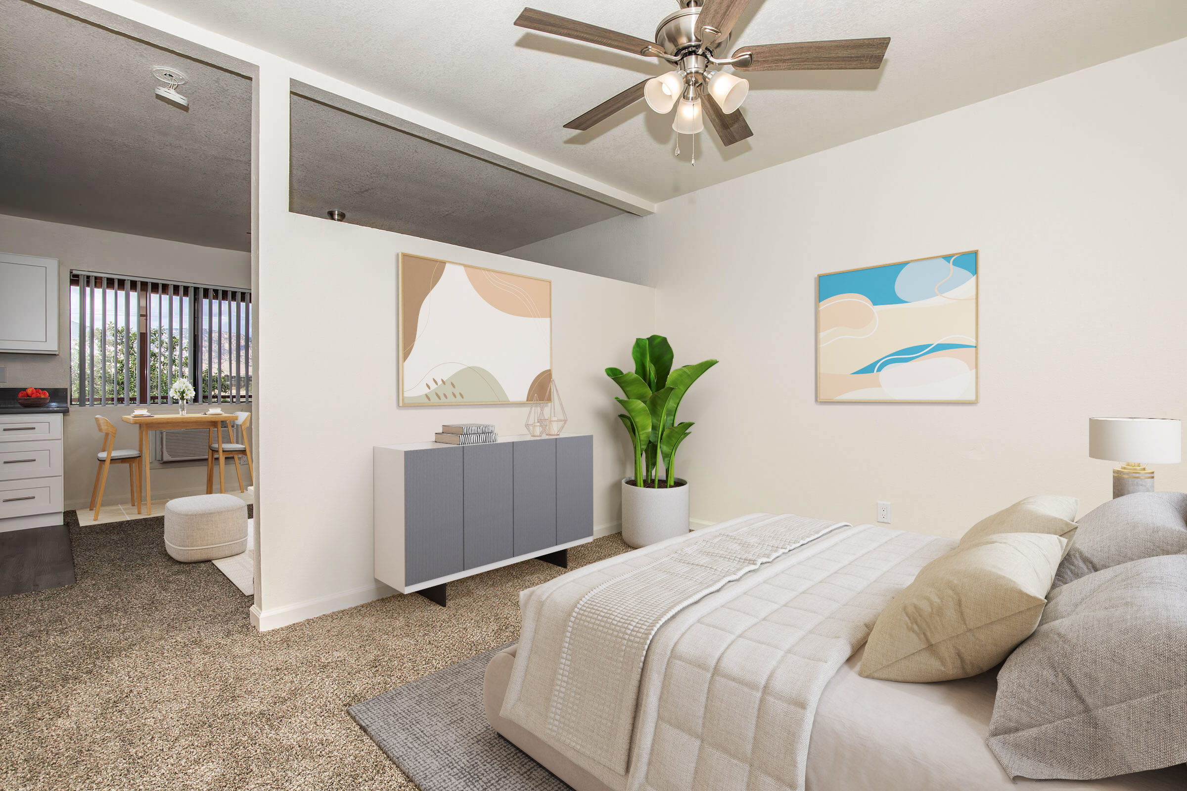 A cozy bedroom featuring a queen-sized bed with neutral bedding, decorative pillows, and a modern bedside lamp. A stylish dresser stands against one wall, topped with decor. In the background, a dining area is visible through an open space, with a large window and natural light streaming in.
