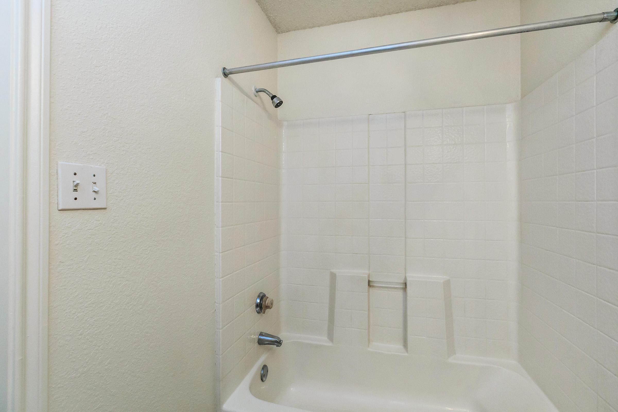 a white sink sitting next to a shower