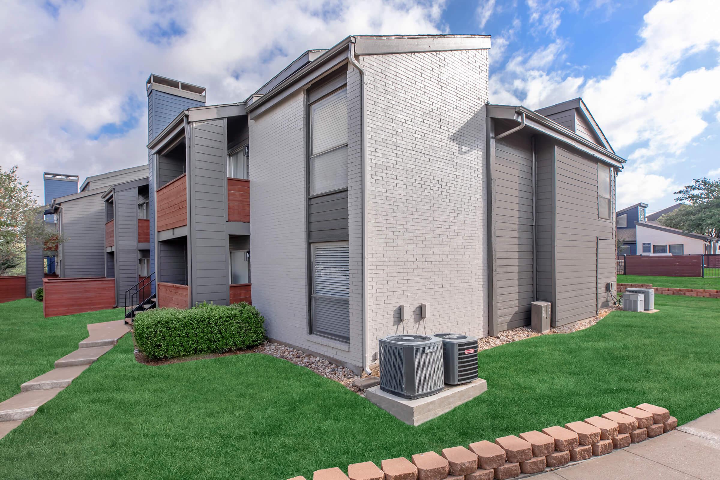 a large lawn in front of a brick building