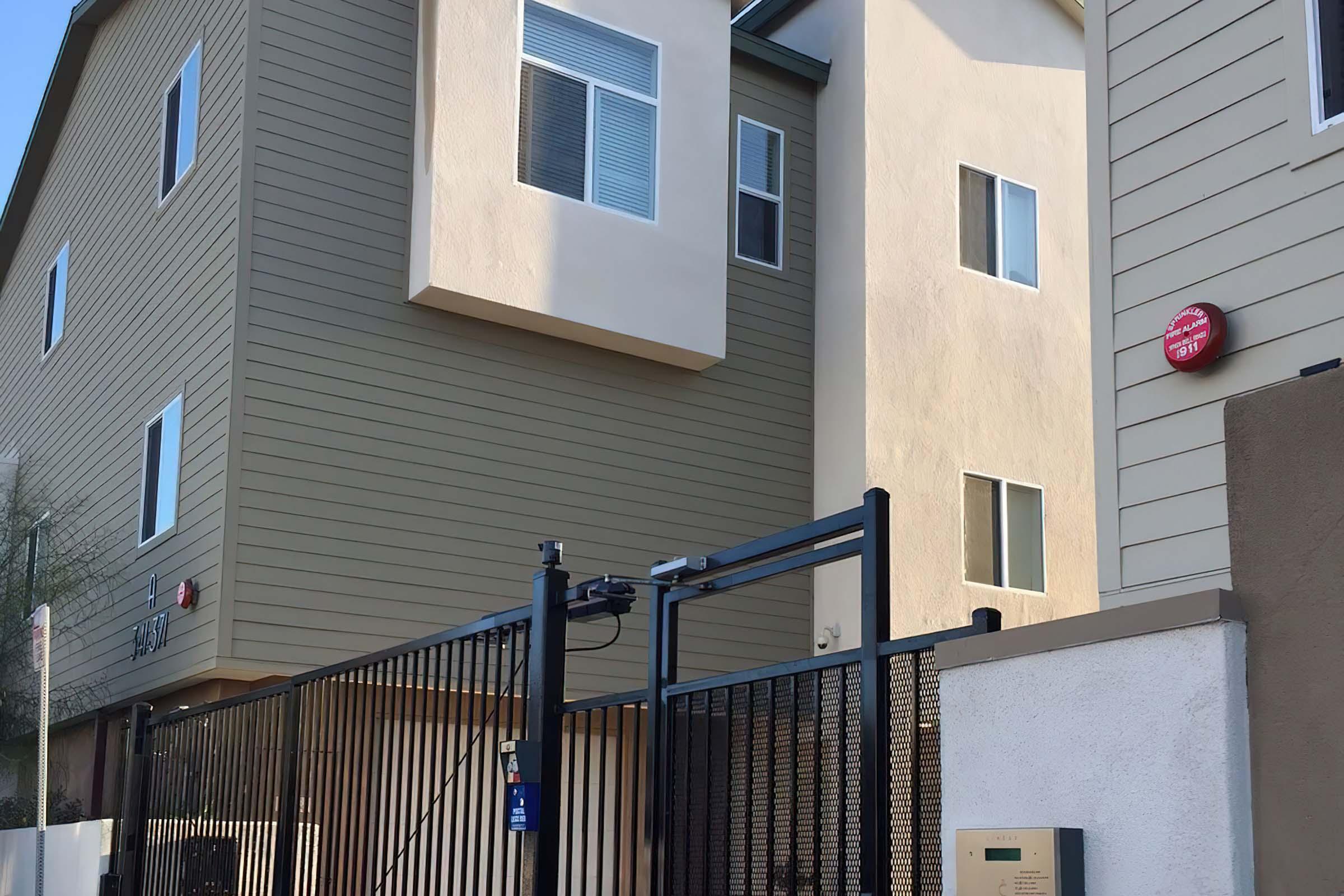 A modern multi-story building with beige and olive green siding.