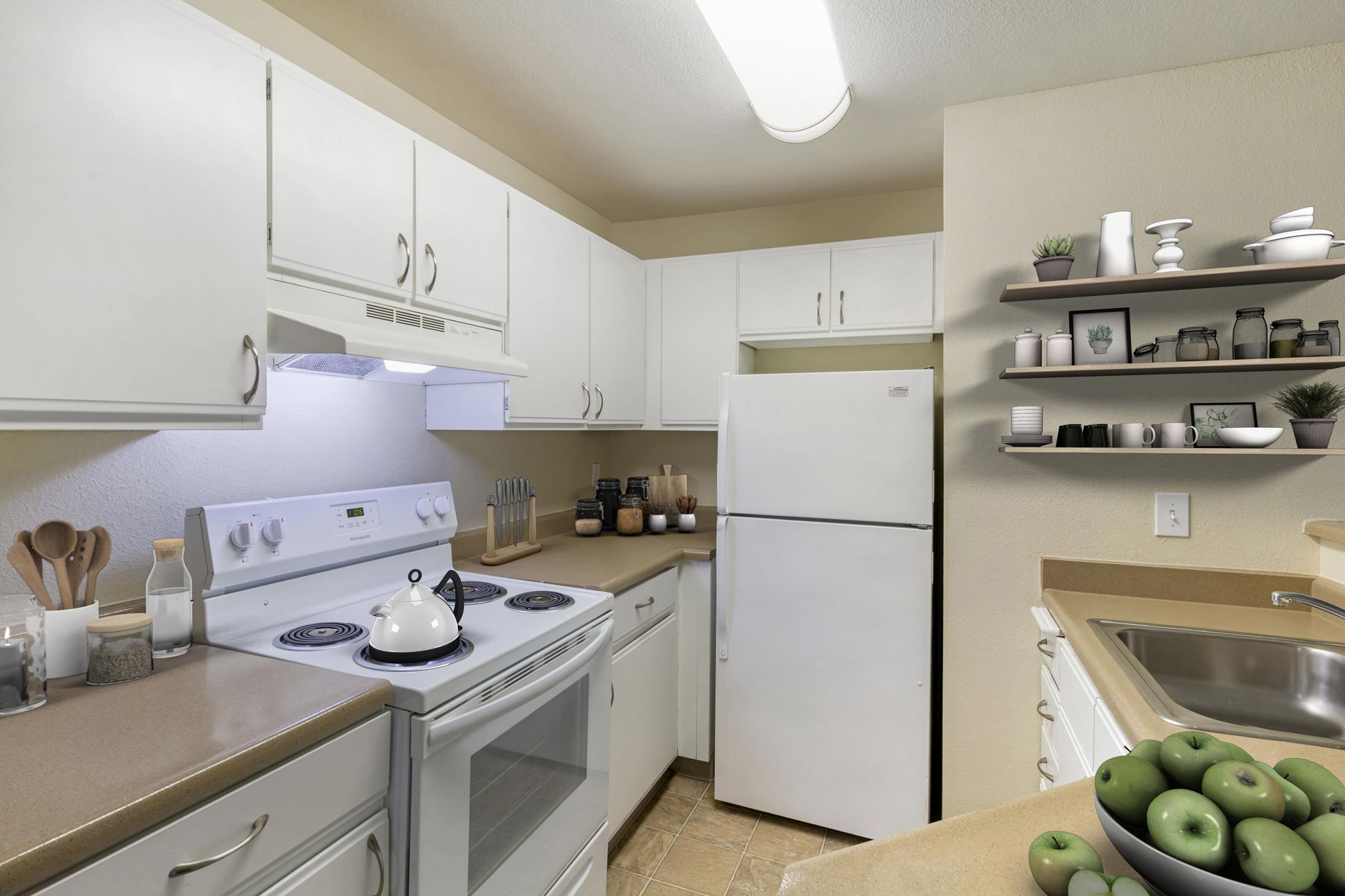 A modern kitchen featuring white cabinetry, a white refrigerator, a stove, and an oven.