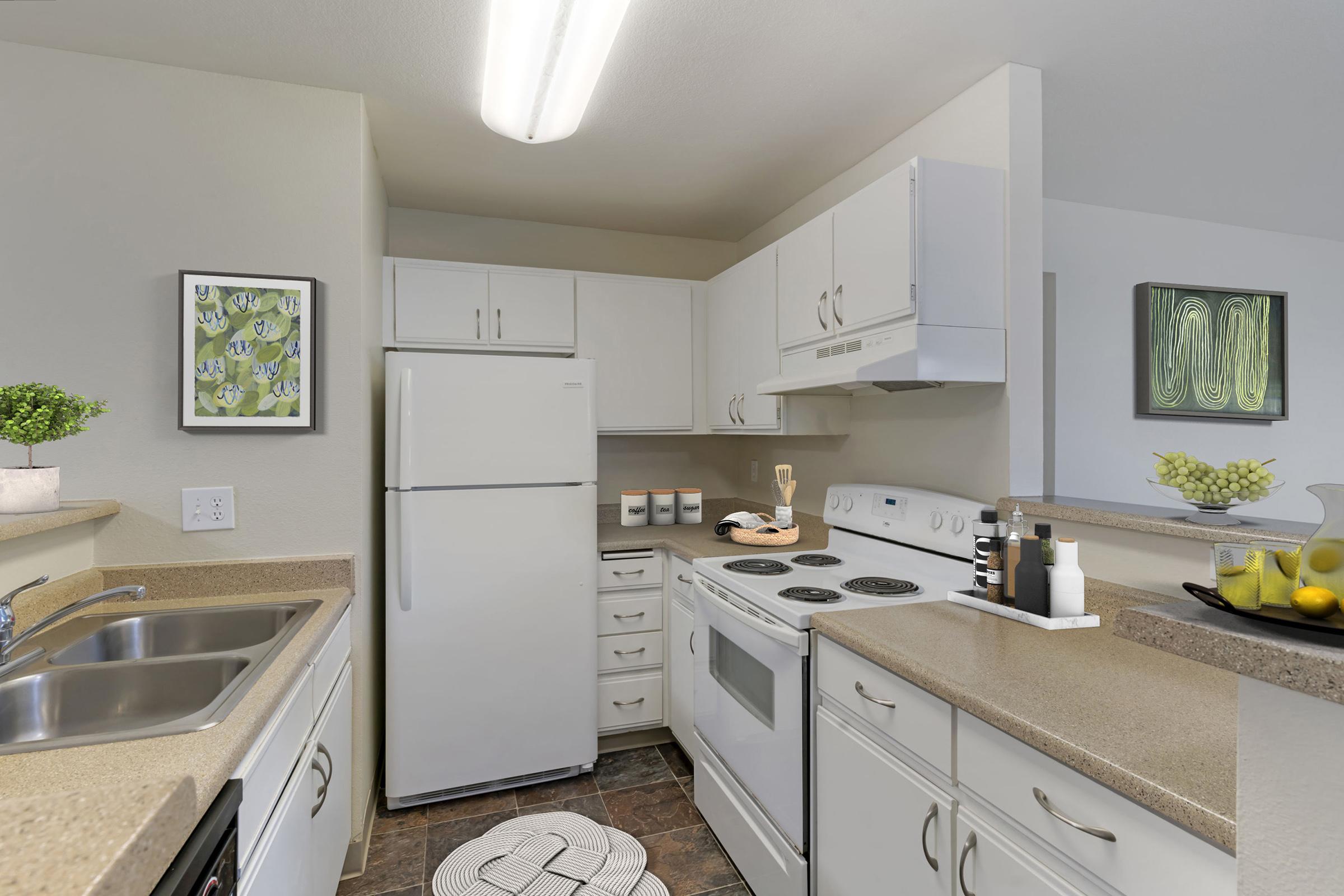 A modern kitchen featuring white cabinetry and appliances, including a refrigerator, stove, and sink.