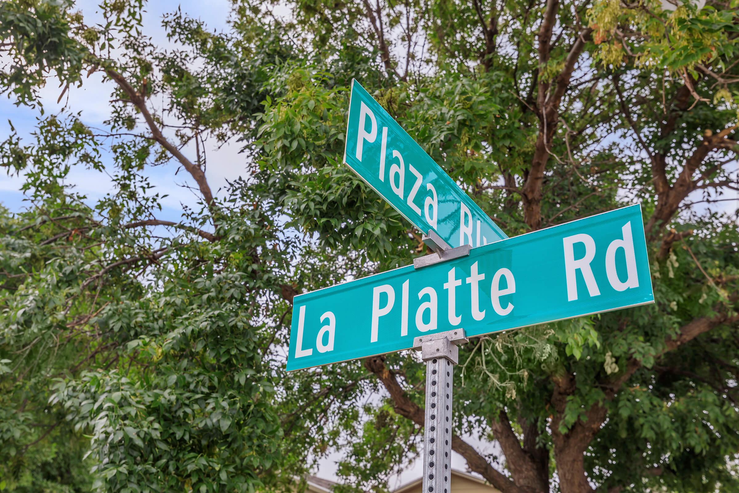 a close up of a street sign in front of a tree