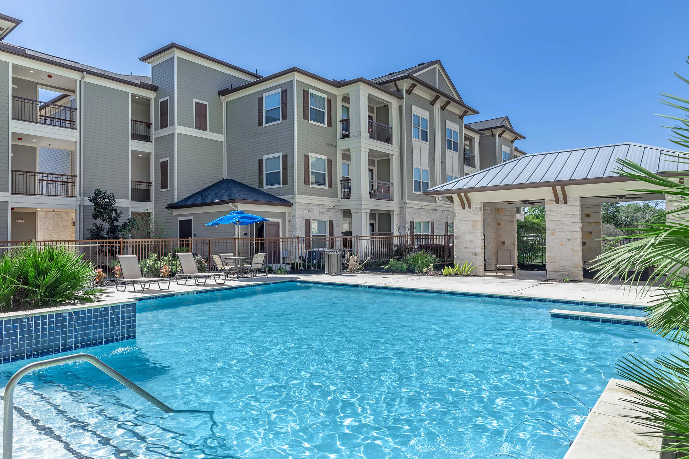 a house with a pool in front of a building