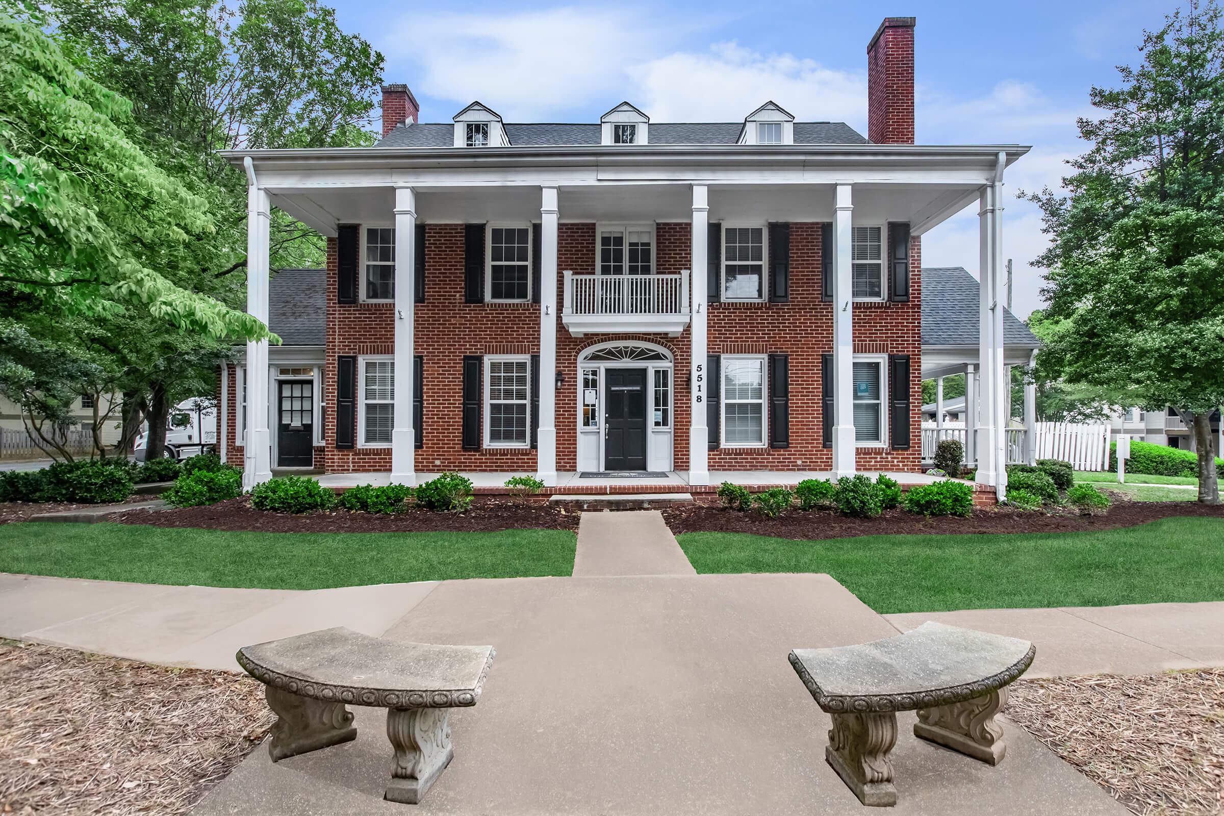 a stone bench sitting in front of a brick building