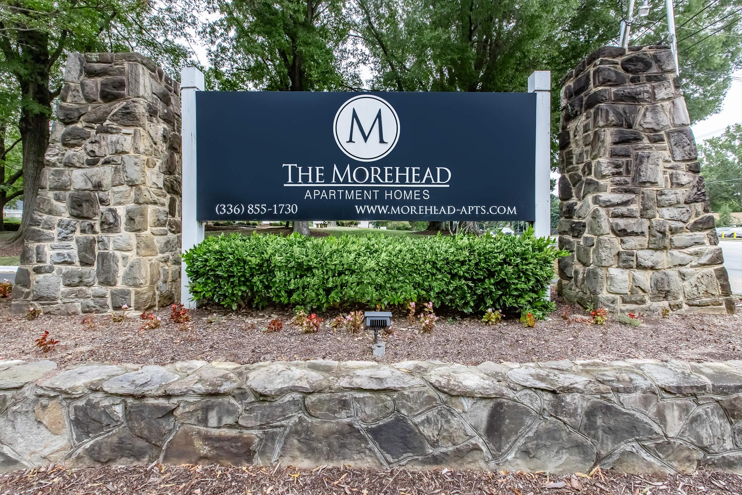 a stone building that has a sign on a rock