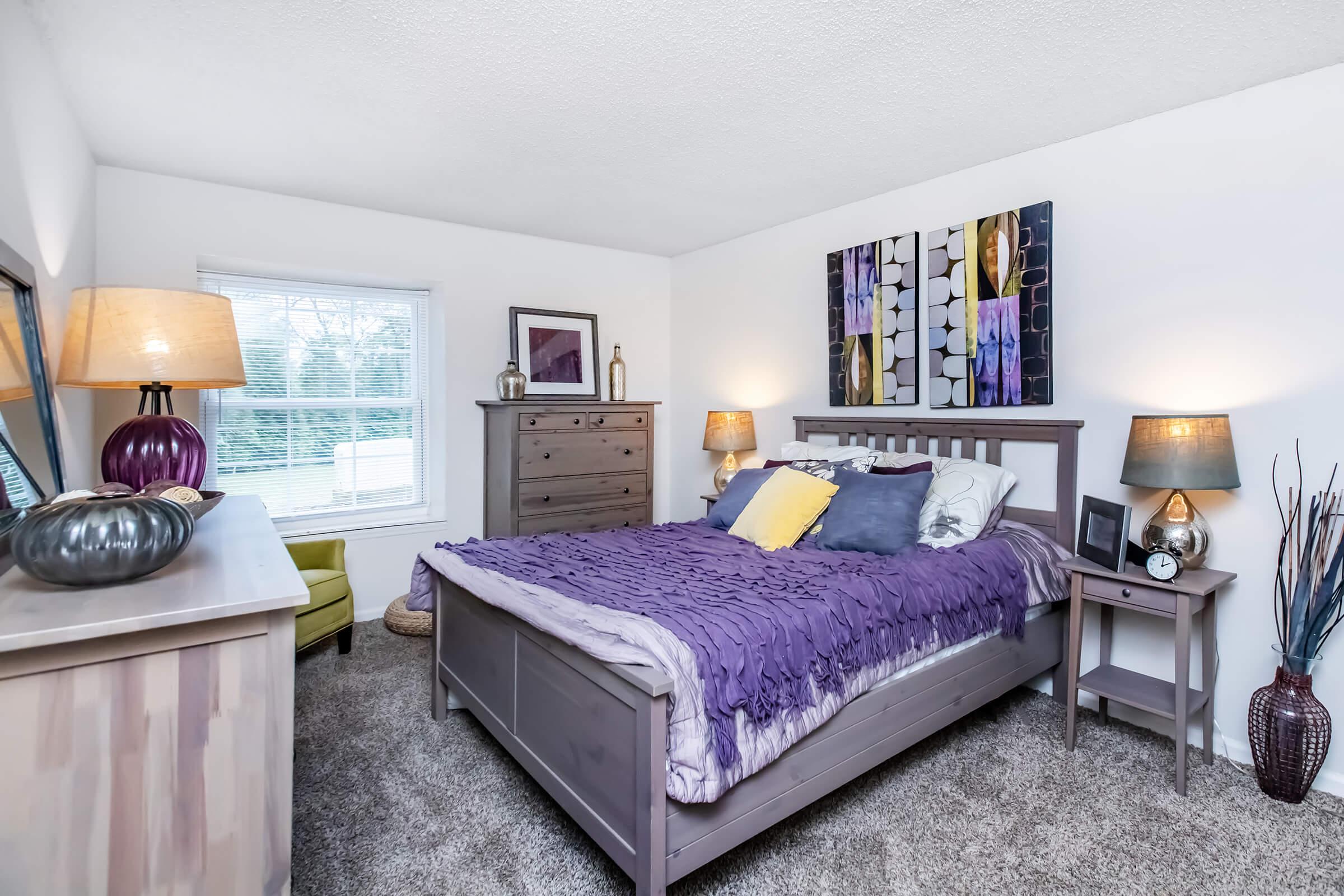 a bedroom with a bed and desk in a room