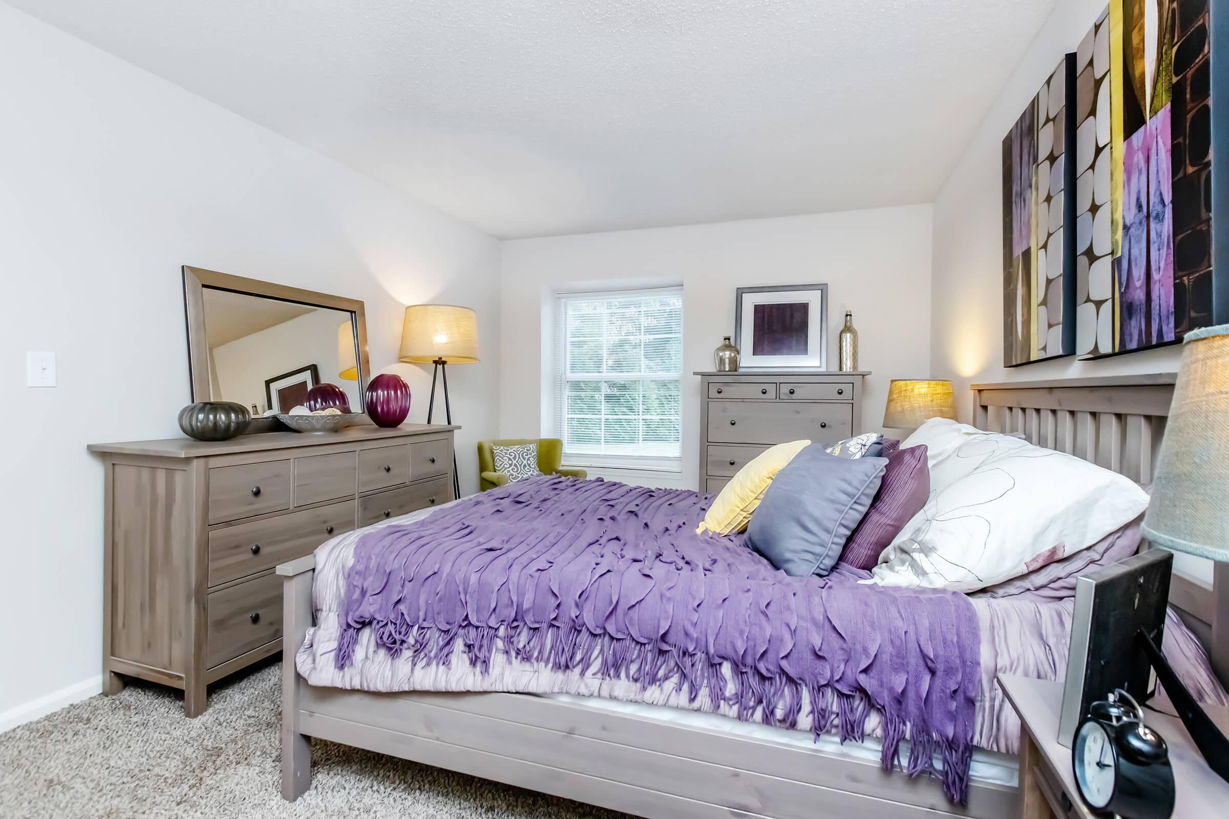 a bedroom with a bed and desk in a room