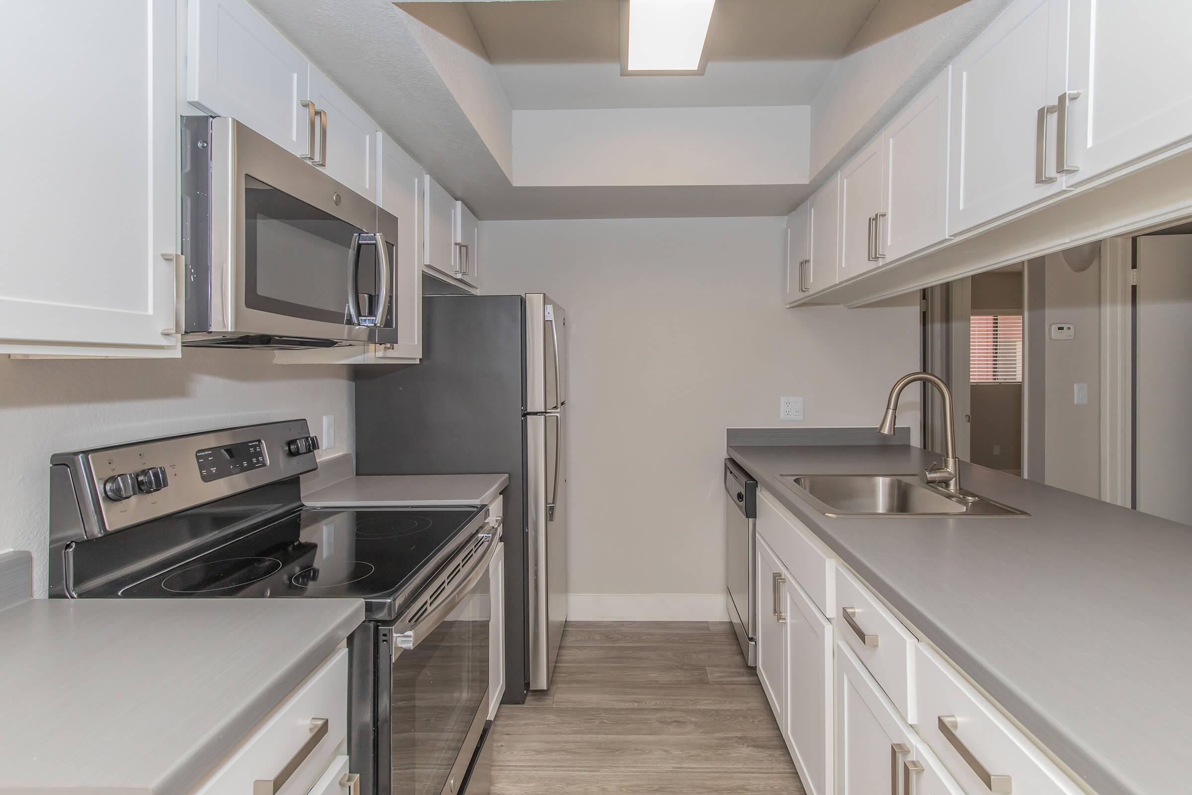 Close up view of modern kitchen with white cabinets and stainless steel appliances