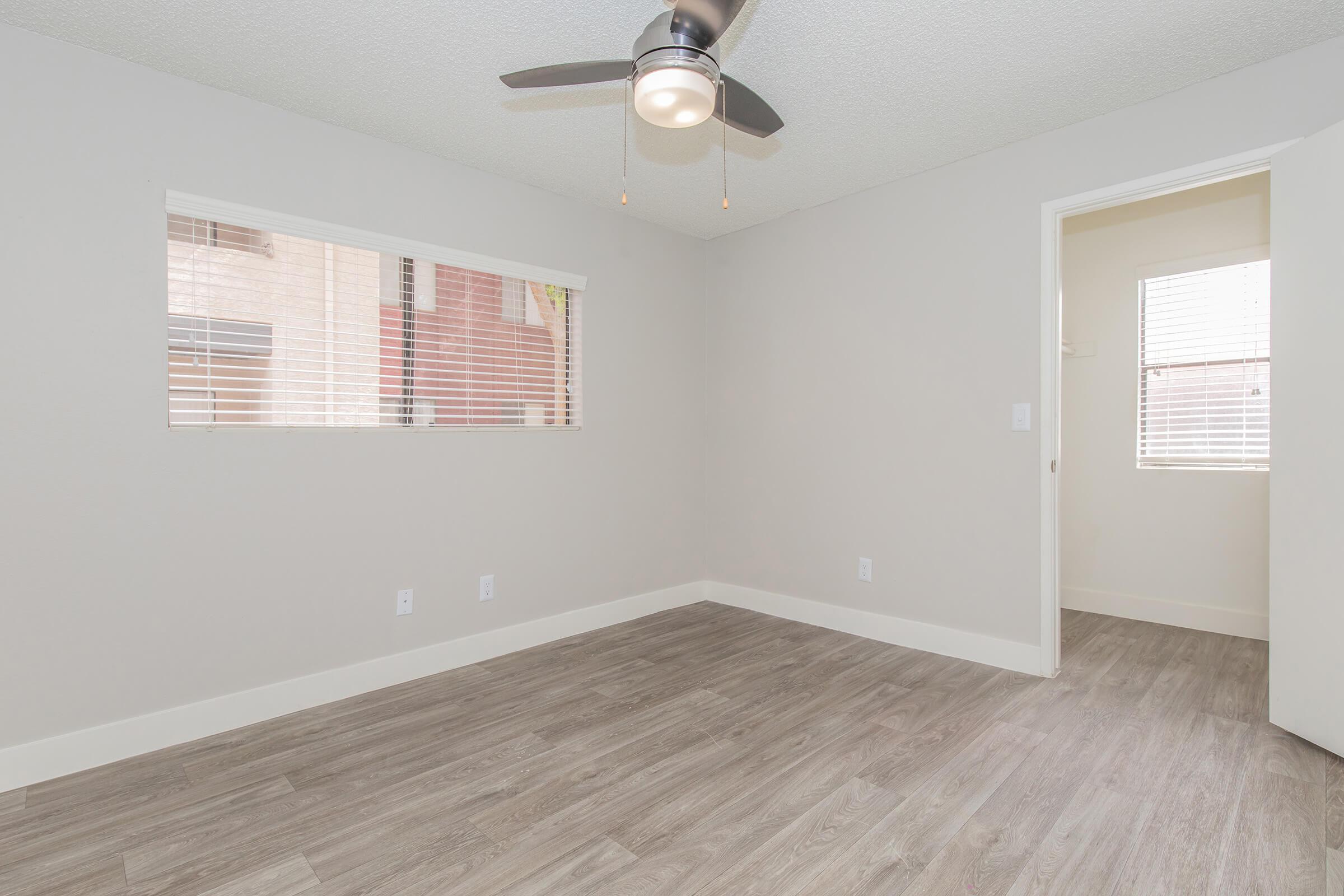 Large modern spacious bedroom with ceiling fan, window, and attached main bathroom