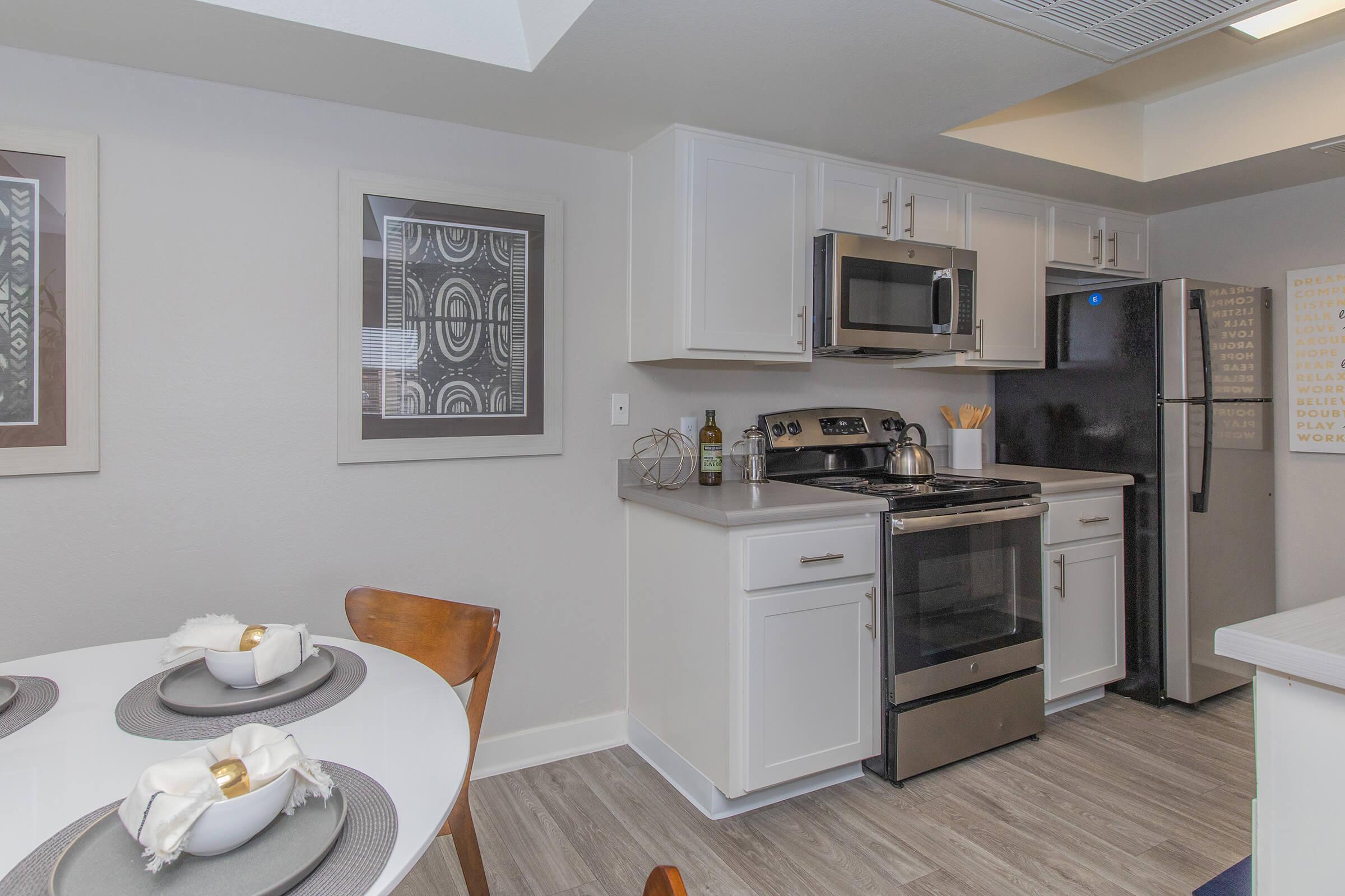 White modern kitchen space next to a modern kitchen dining set