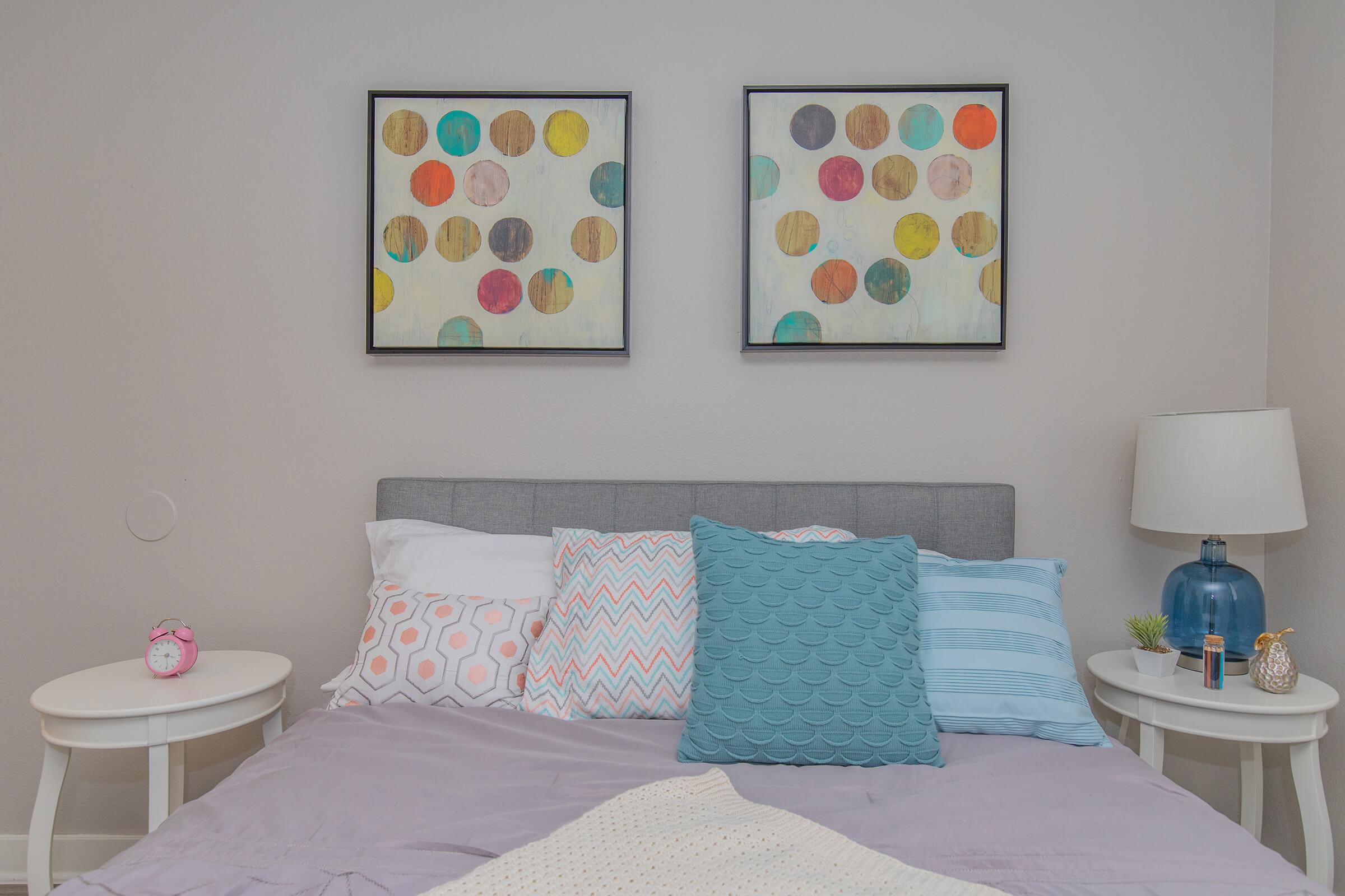 Large bed with 2 side tables and art above the bed