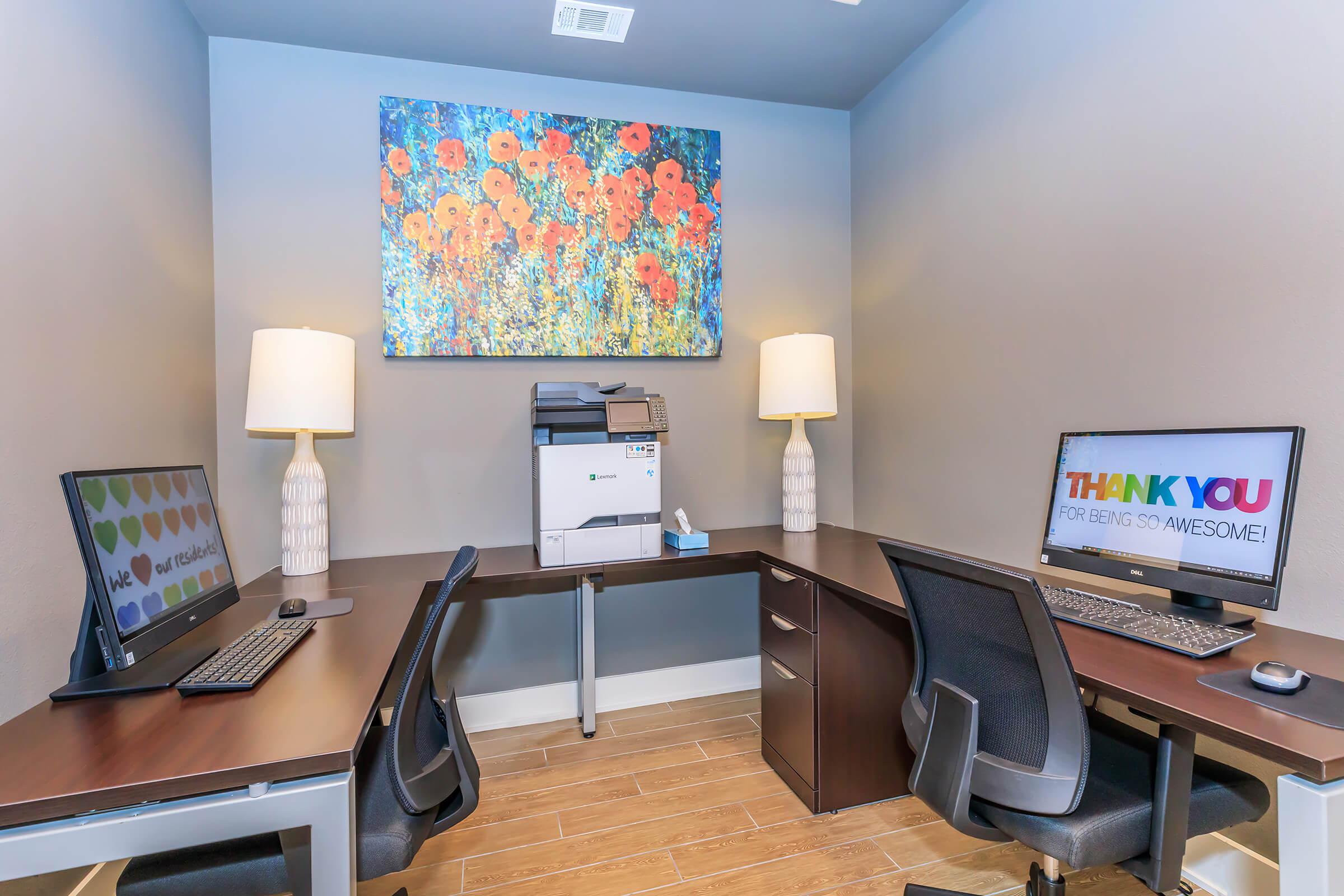 a desk with a computer and a chair in a room