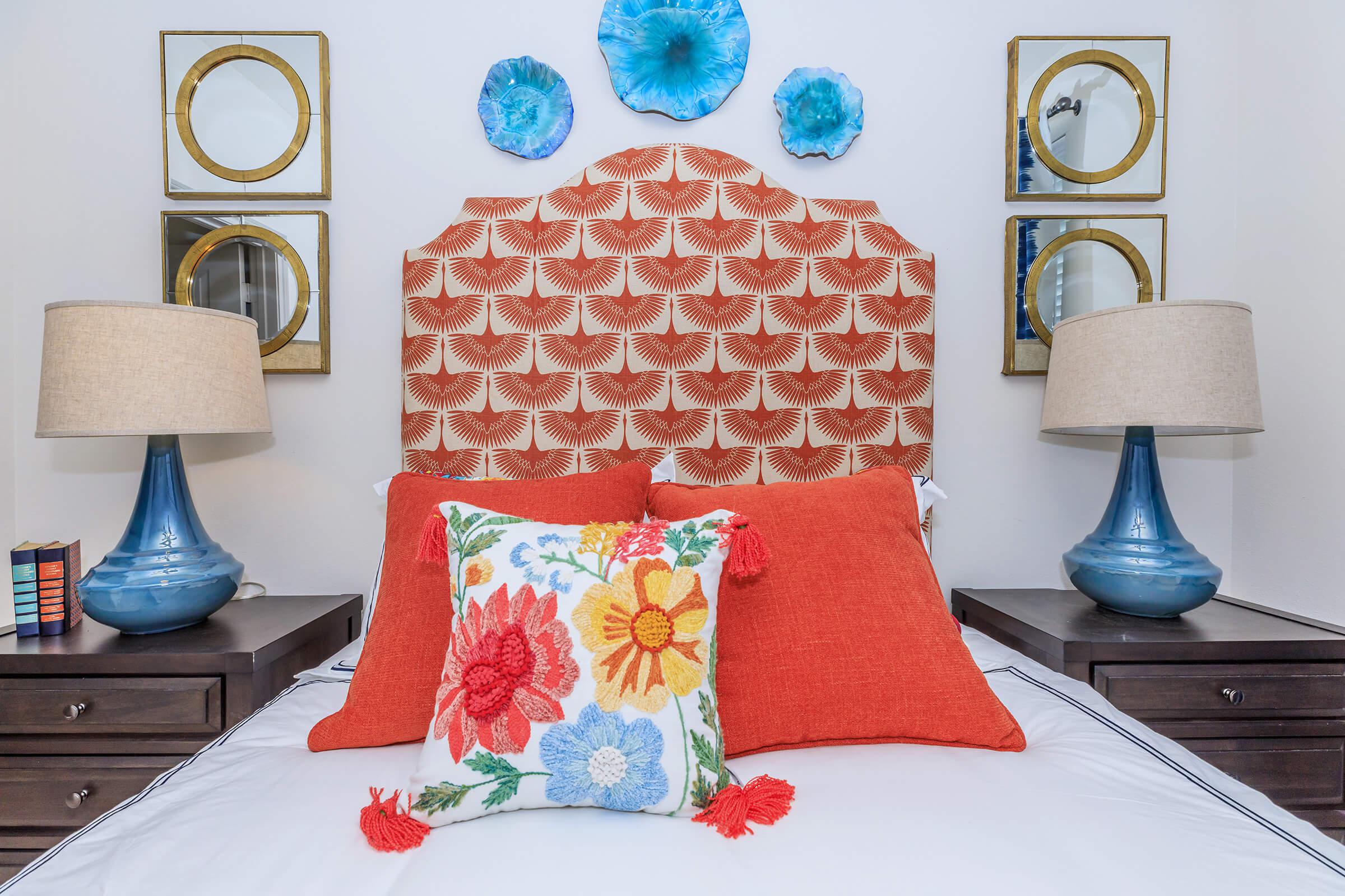 a bedroom with a bed and a vase of flowers on a table