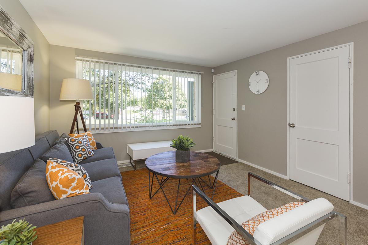 a living room filled with furniture and a large window