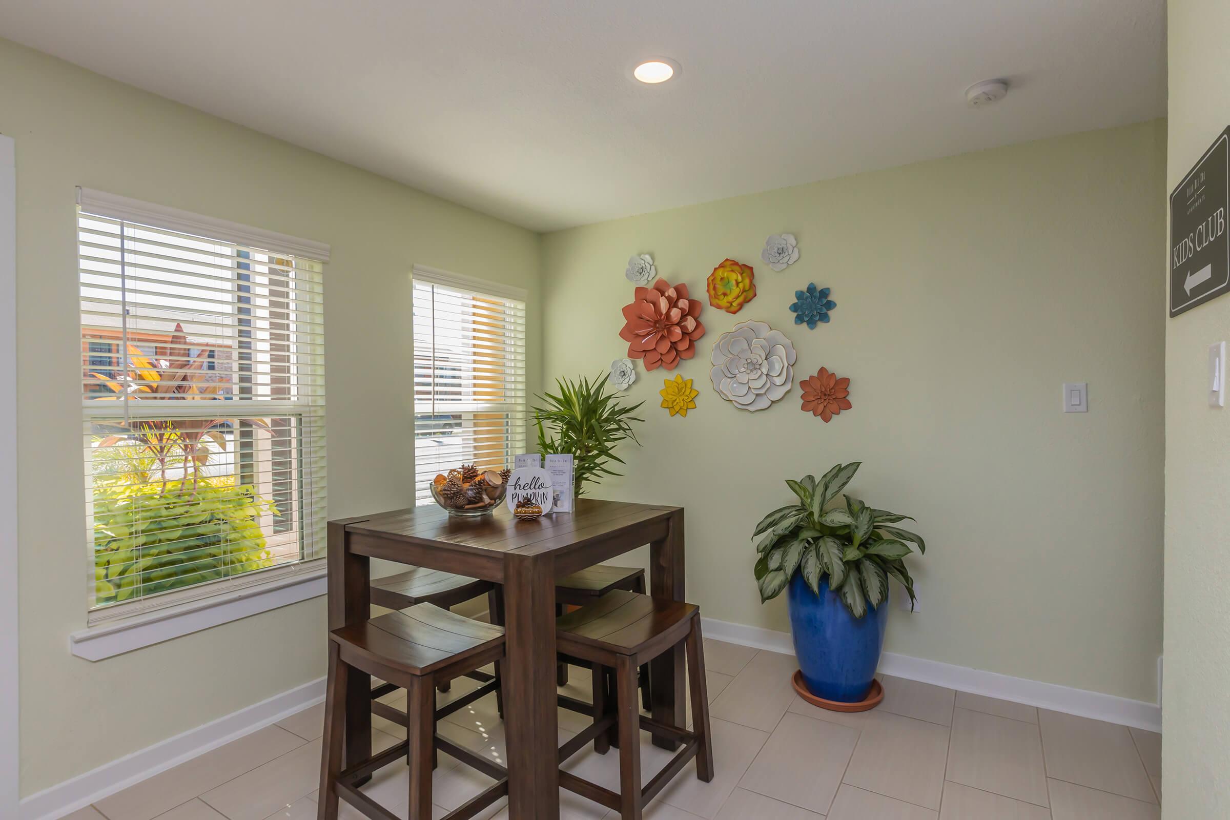 a room filled with furniture and vase of flowers on a table