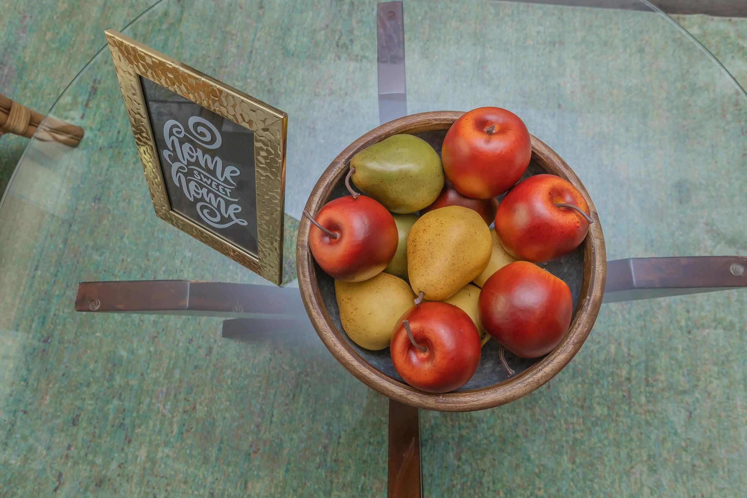 a bowl of fruit sitting on top of a wooden table