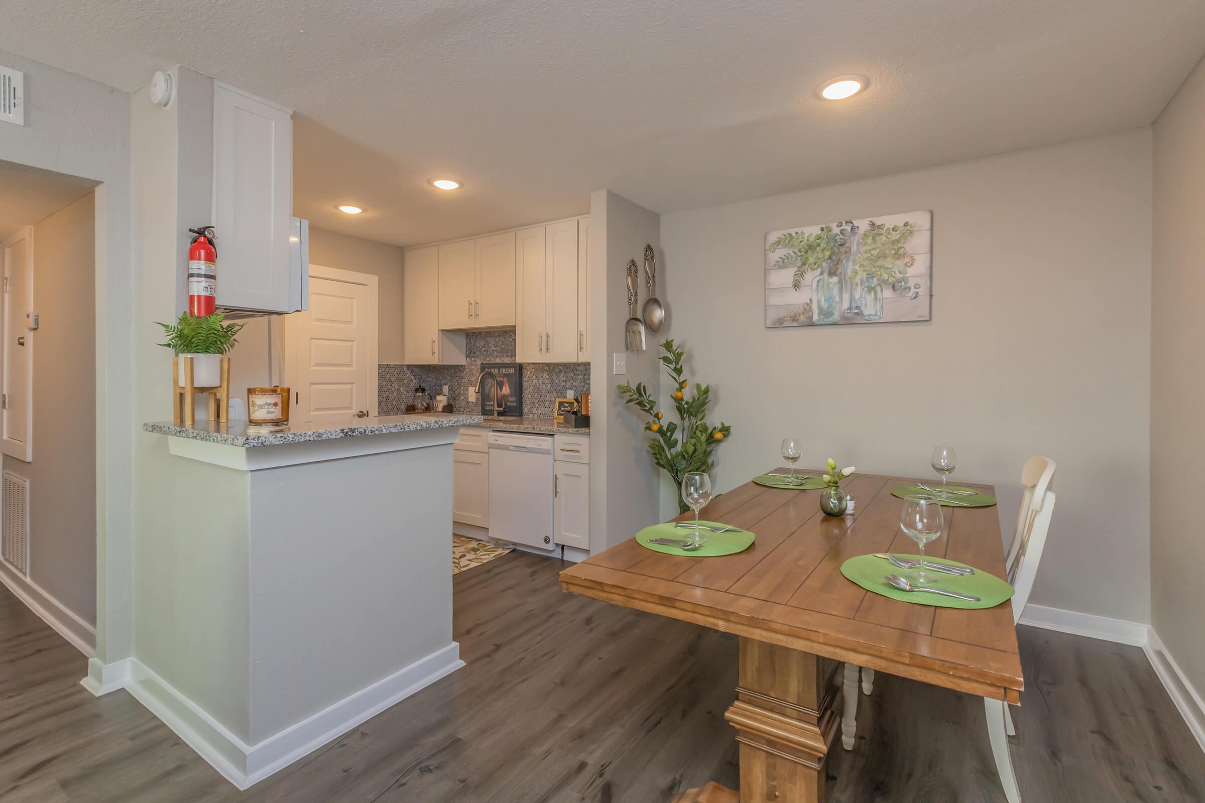 a kitchen with wooden furniture and vase of flowers on a table