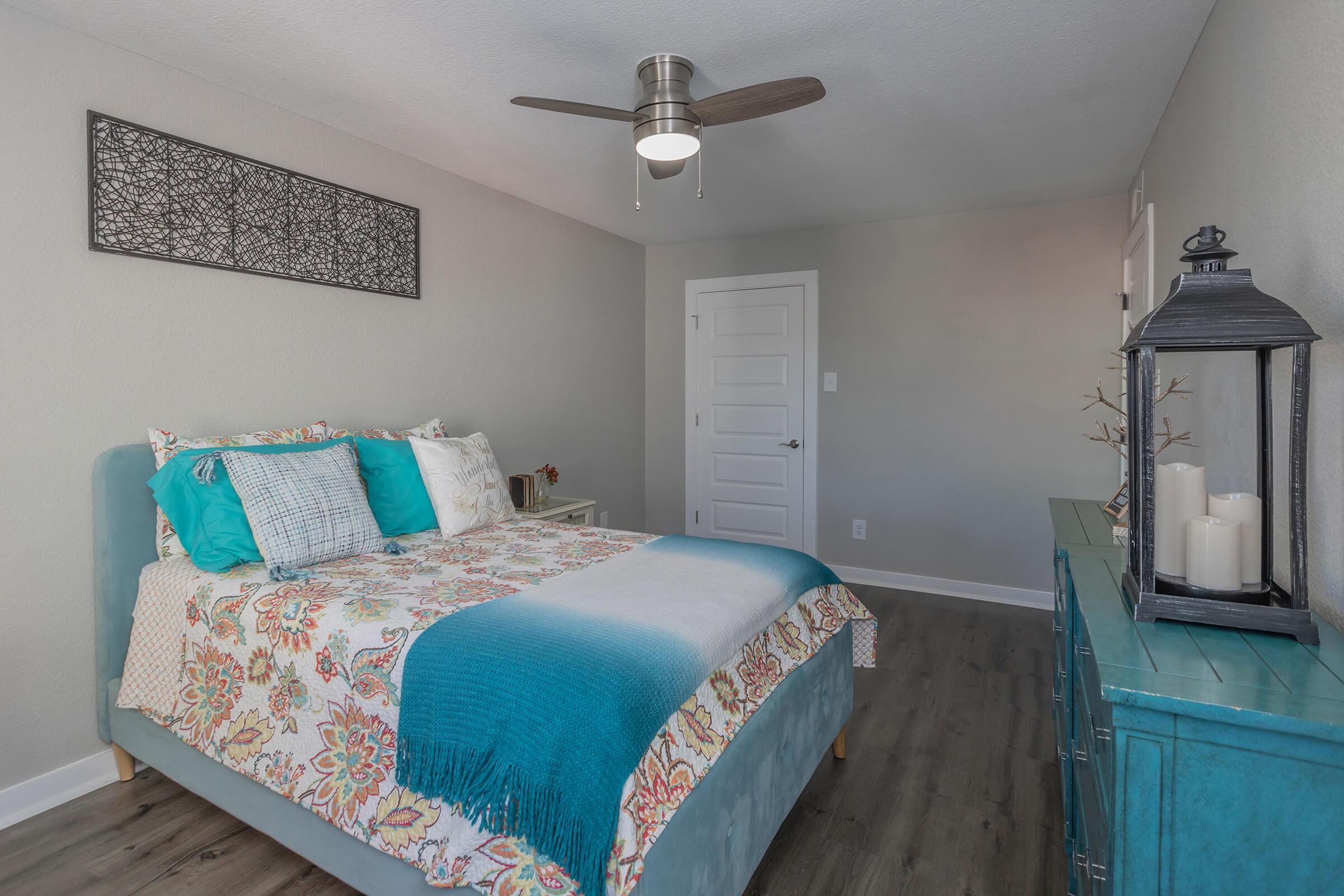 a bedroom with a blue and green bed in a room