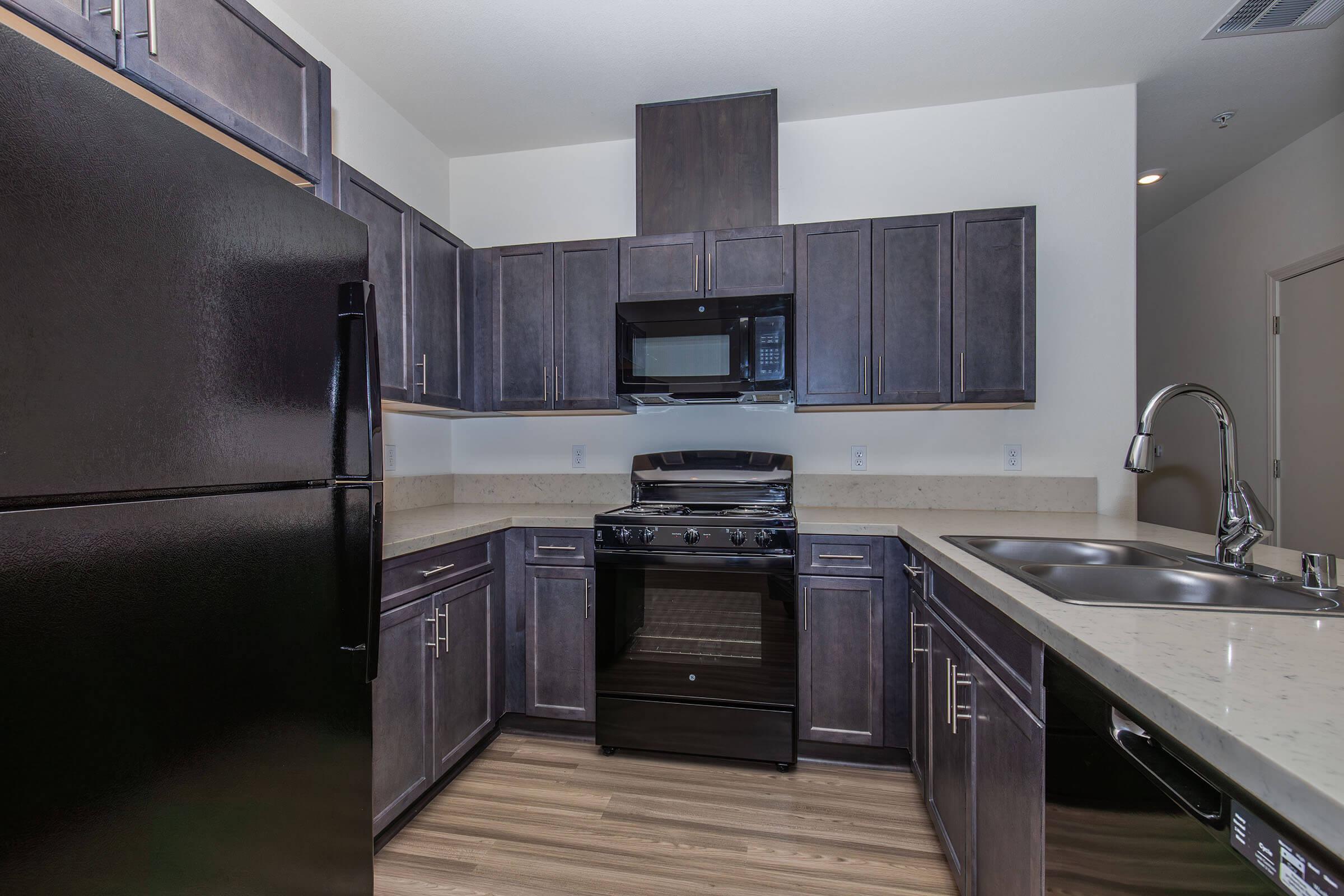 a large kitchen with stainless steel appliances and wooden cabinets