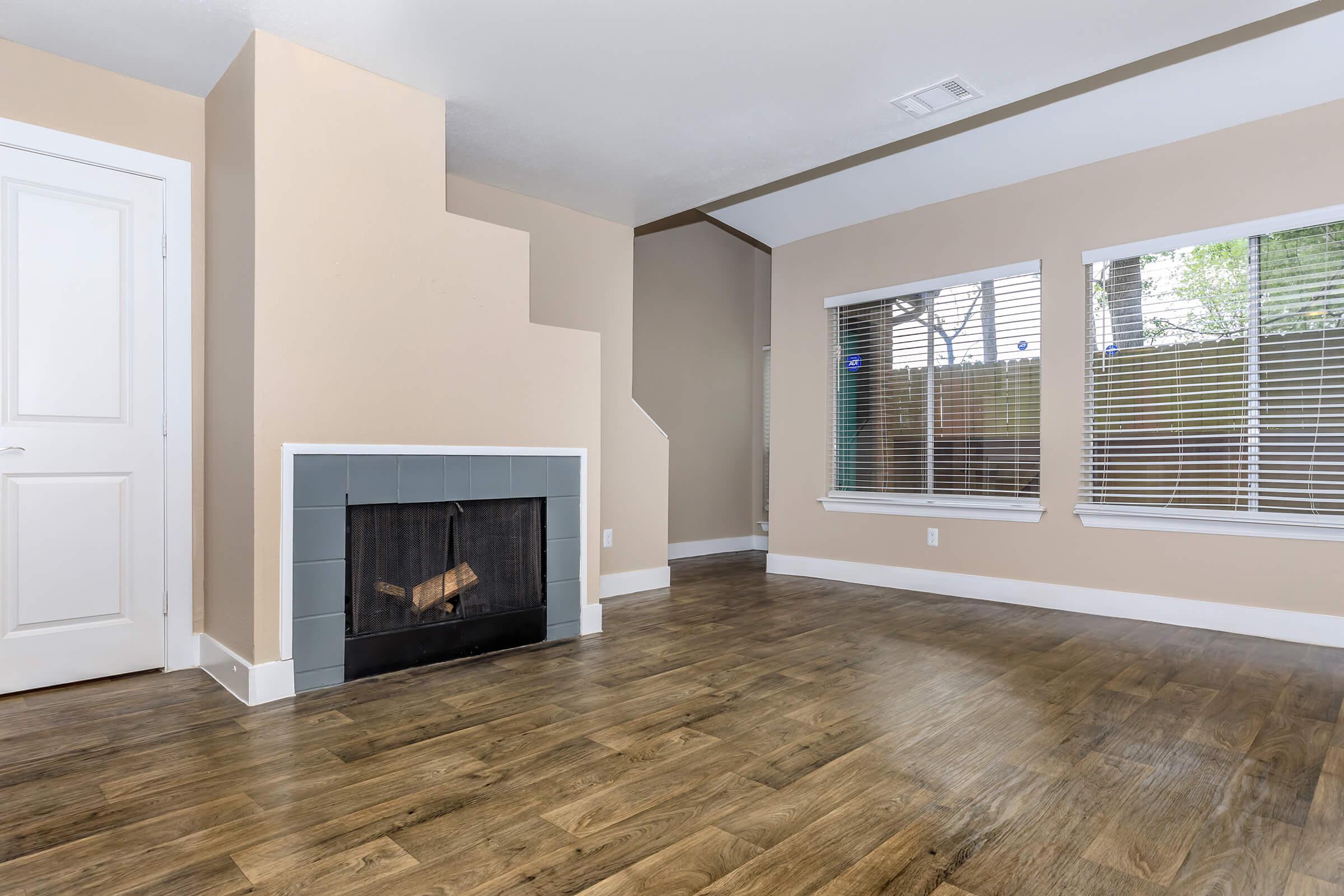 a living room with a fireplace and a large window