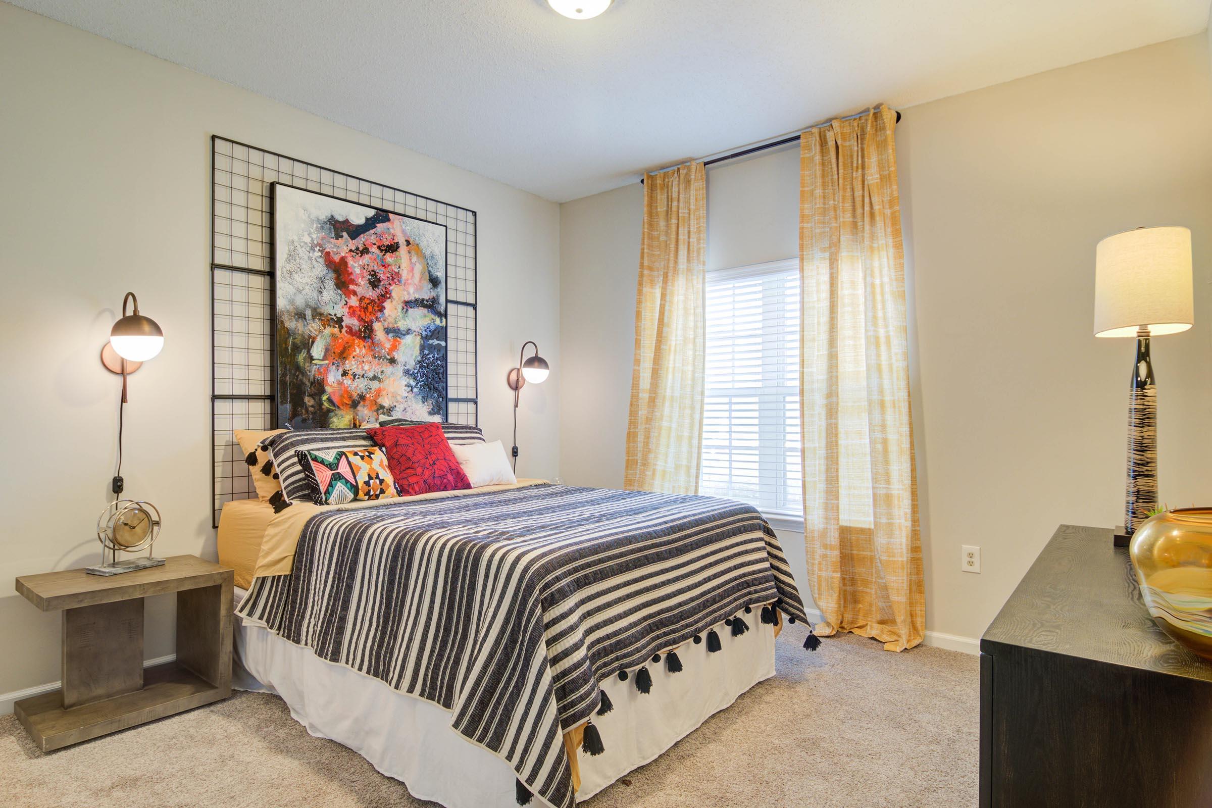 a bedroom with a bed and desk in a room