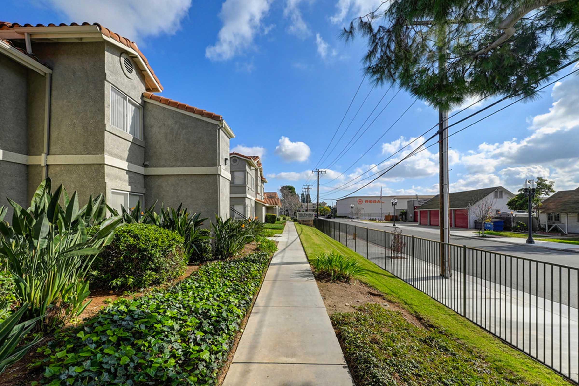 a path with trees on the side of a building