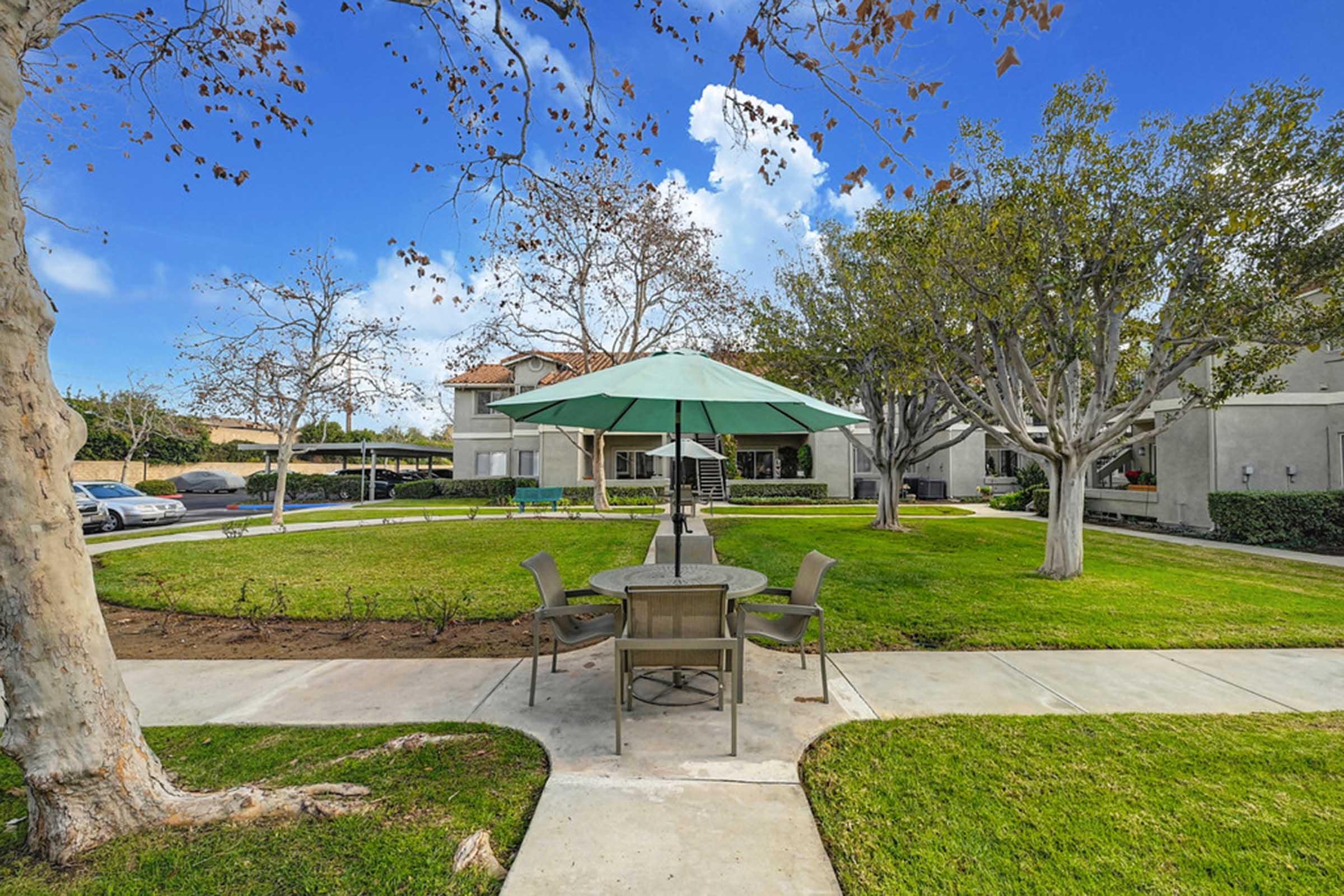 a table with an umbrella in a courtyard