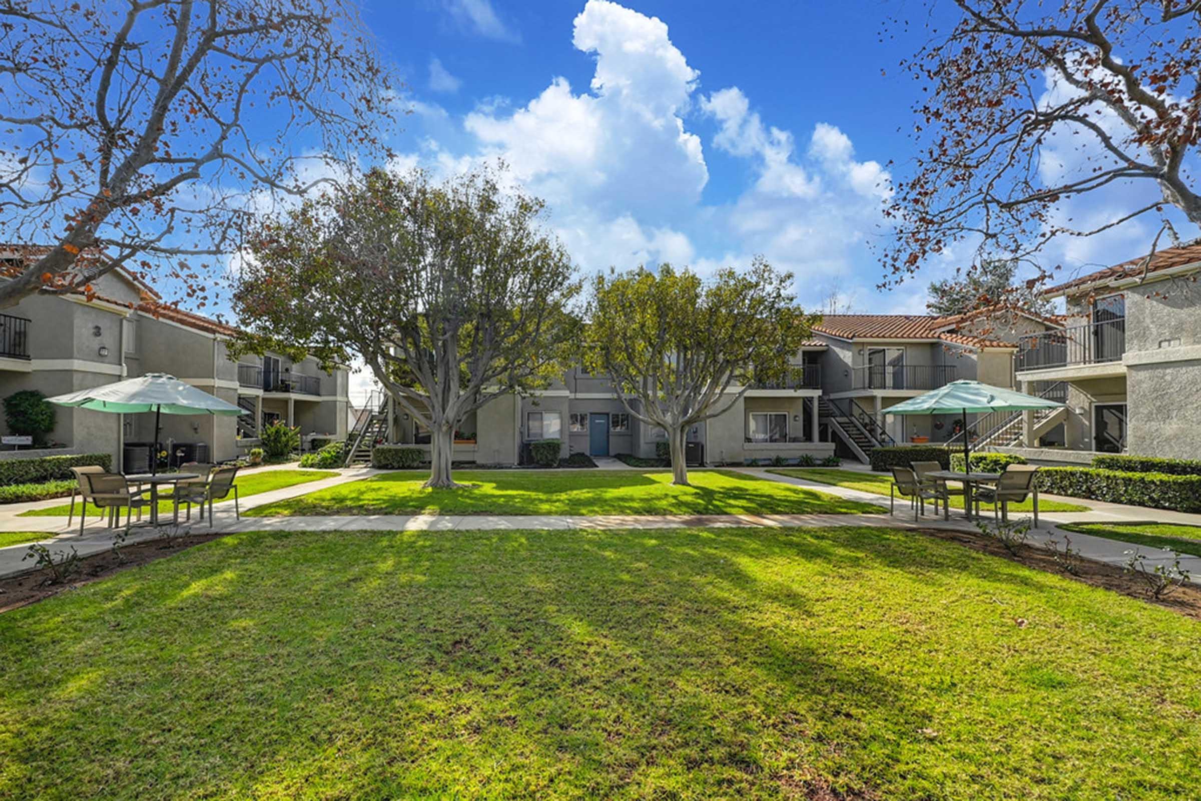 a large lawn with tables in front of a building