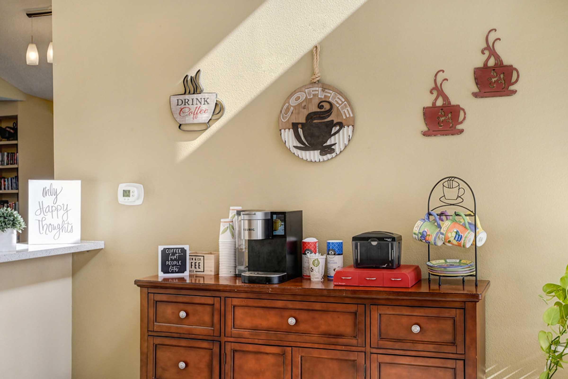 a coffee bar with wooden cabinets