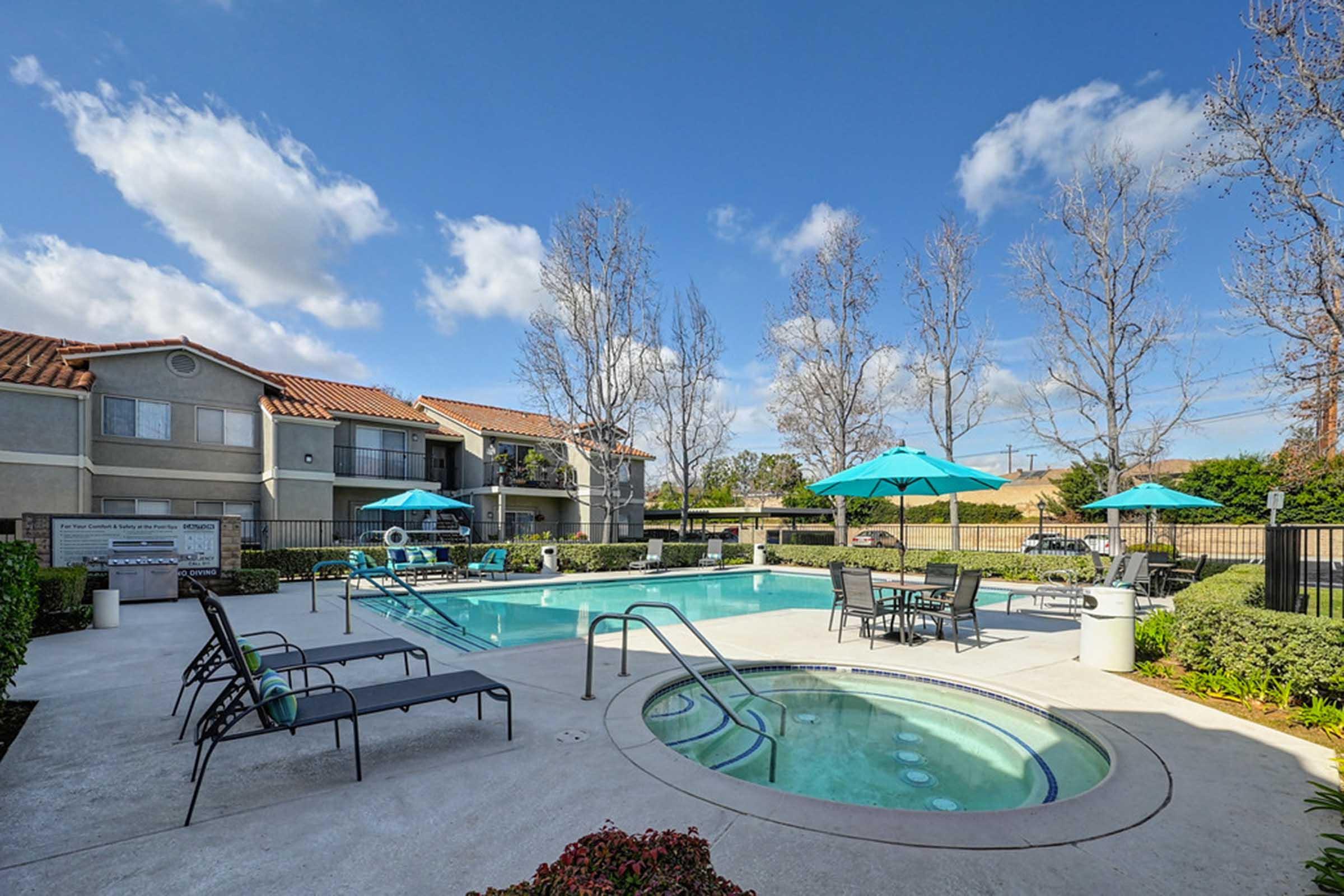 a couple of lounge chairs next to a spa