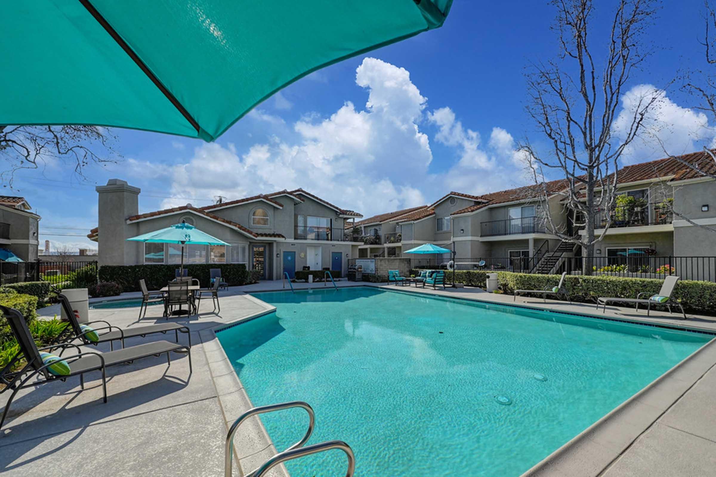 a pool with a green umbrella