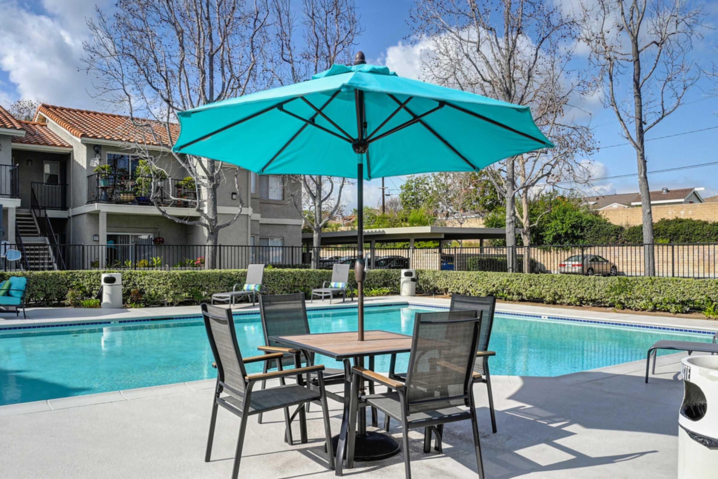 an outdoor table with a blue umbrella