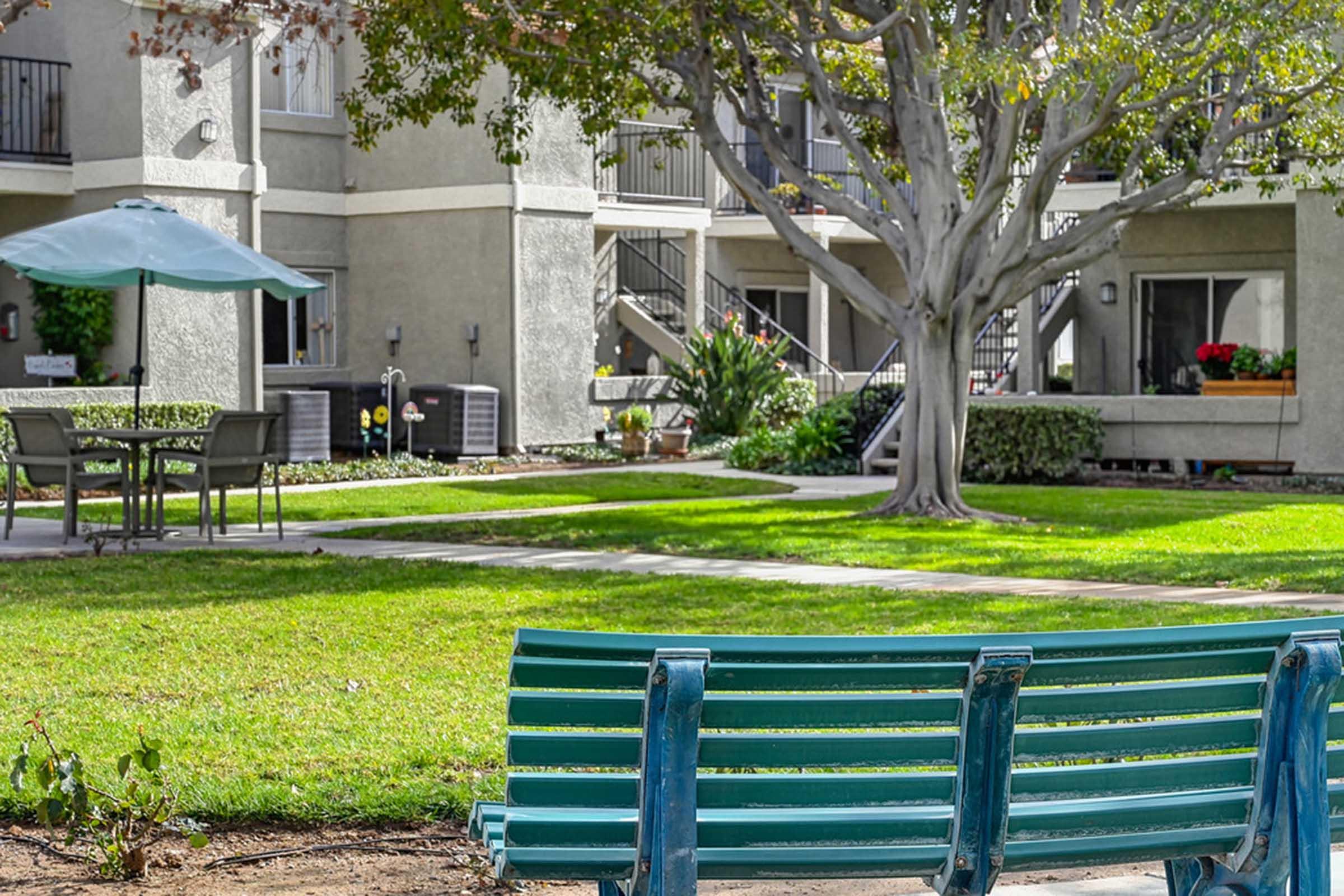 a green bench sitting in the middle of a courtyard